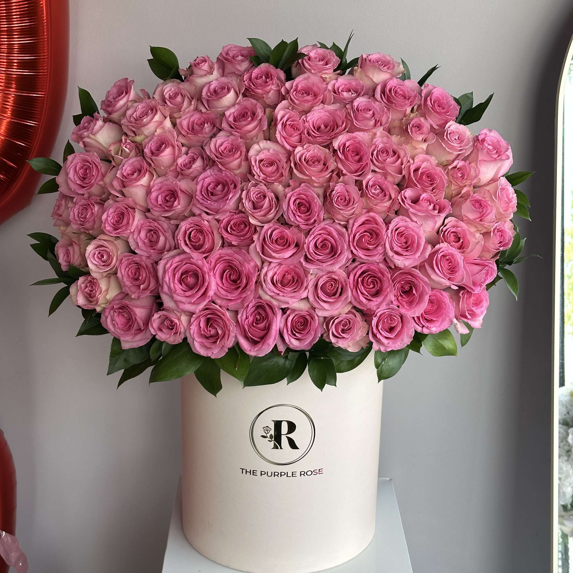 Large dome of pink roses arranged in a white hat box container