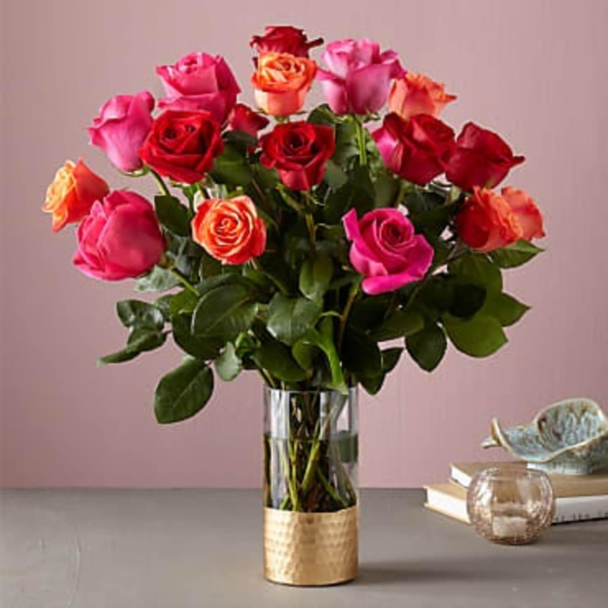 Bouquet of red, pink, and orange roses in a glass vase