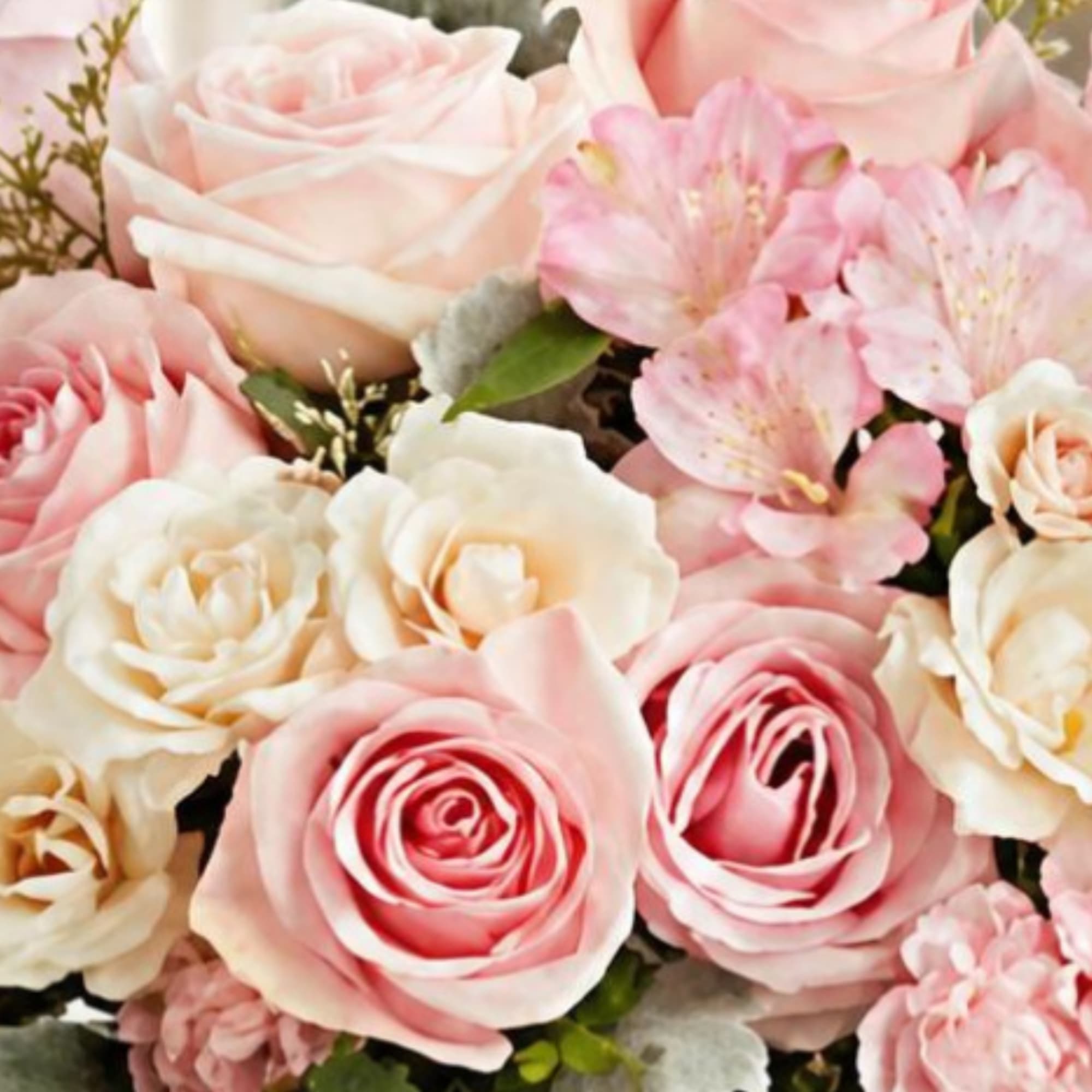 Close-up bouquet of pale pink and cream roses with pink blossoms