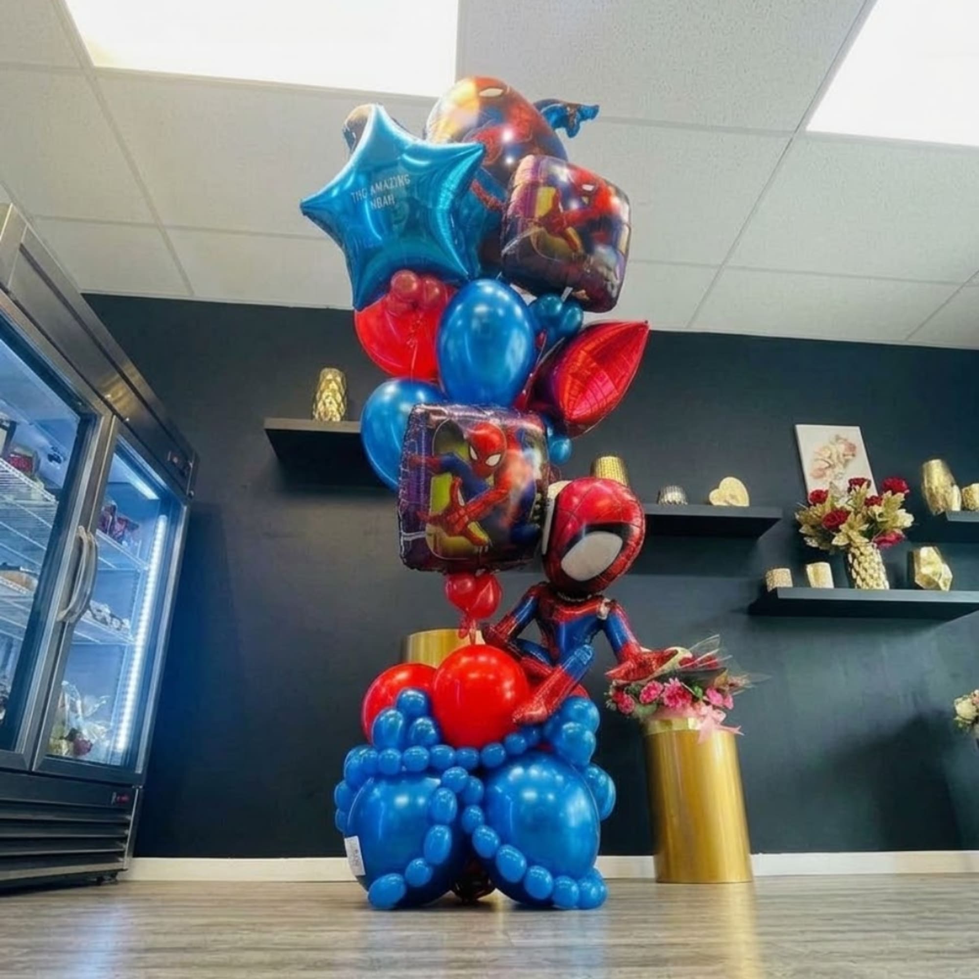 Spider-Man themed balloon display with a small flower bouquet nearby