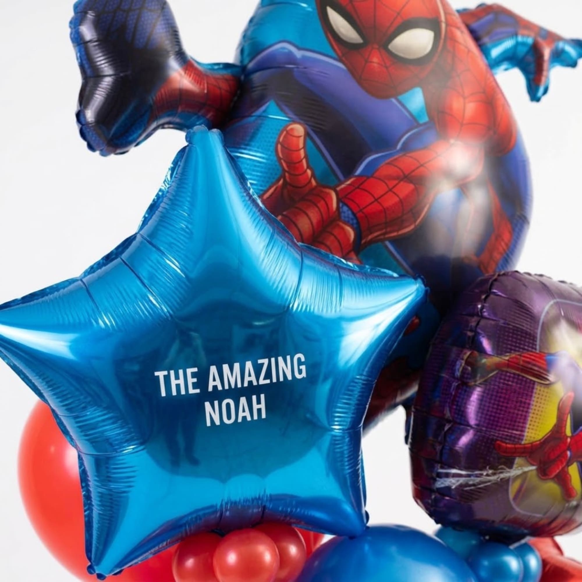 Spider-Man themed balloons with a blue star balloon reading "THE AMAZING NOAH"