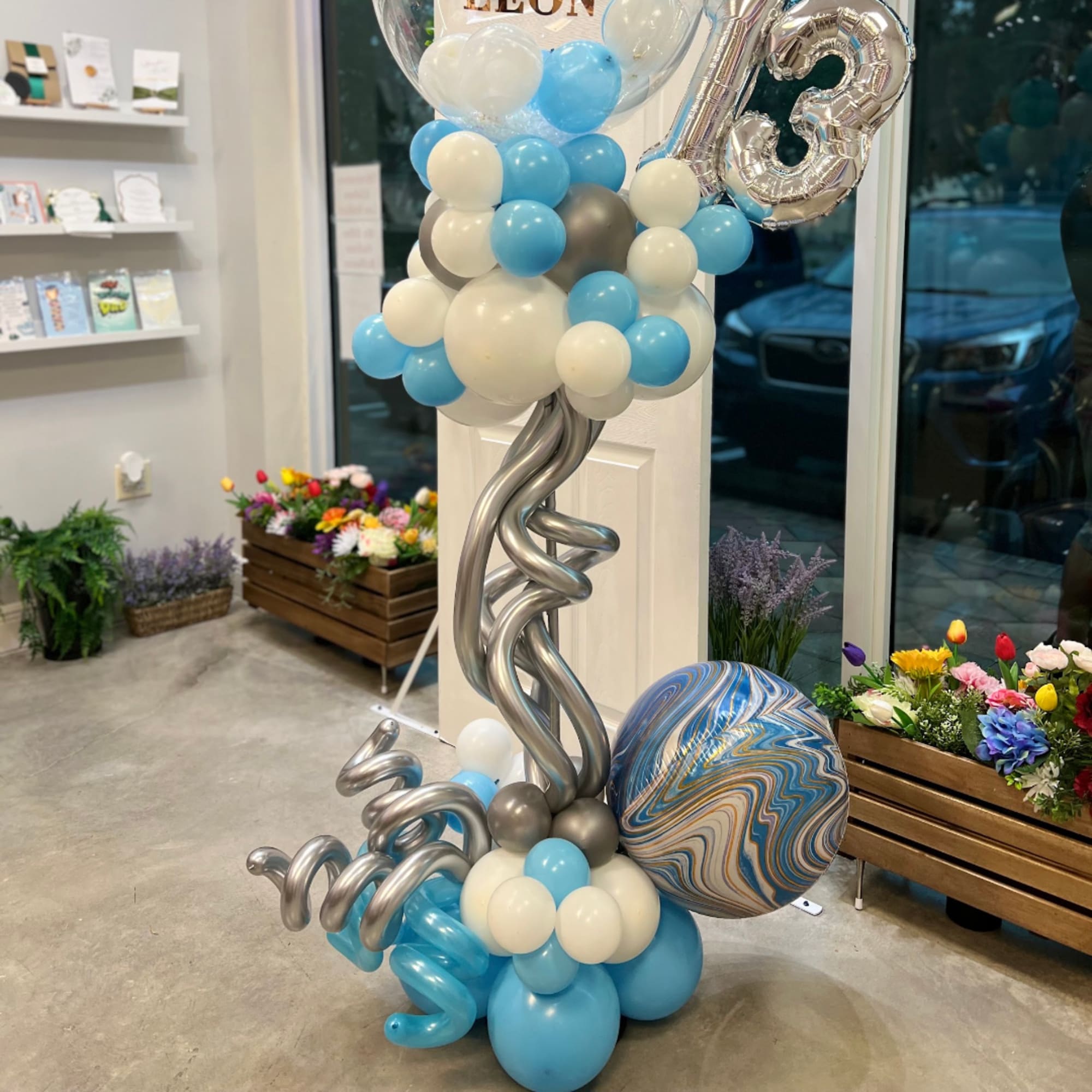 Blue, white, and silver balloon display with a large 13 balloon