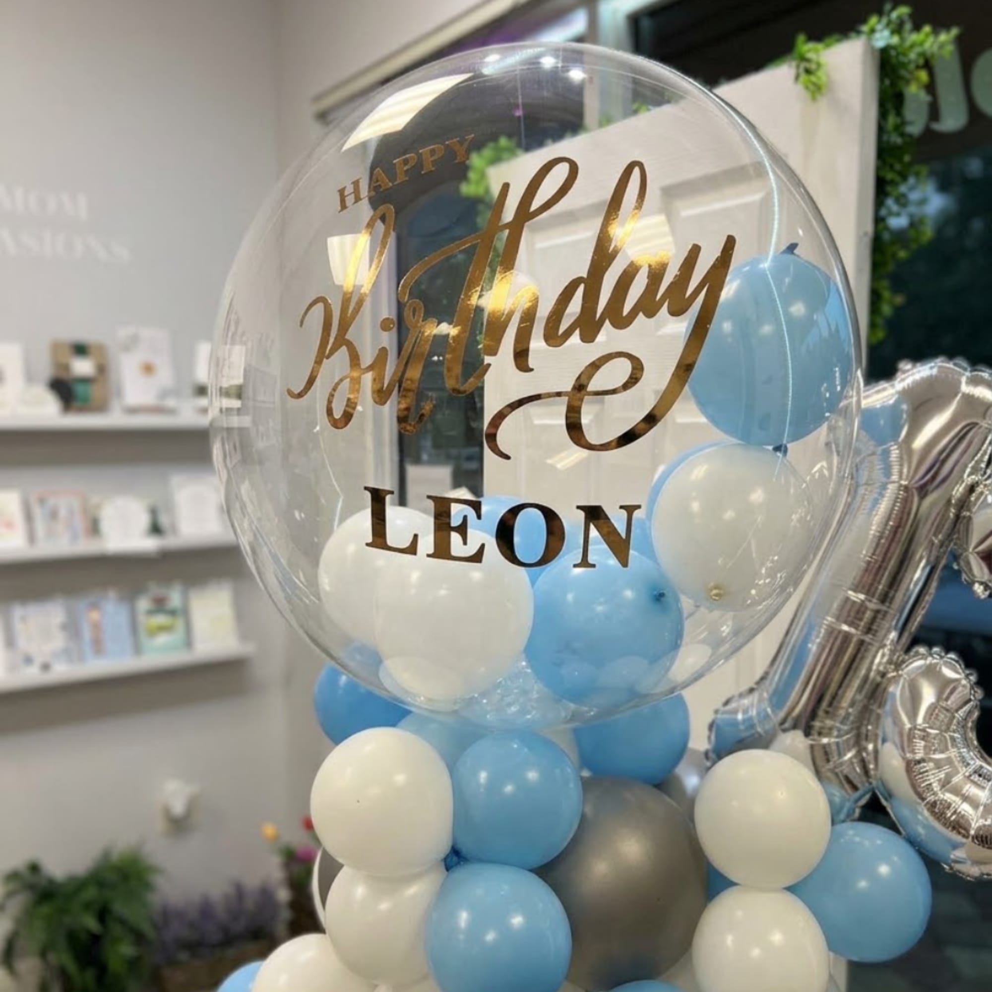 Clear birthday balloon with blue and white balloons inside