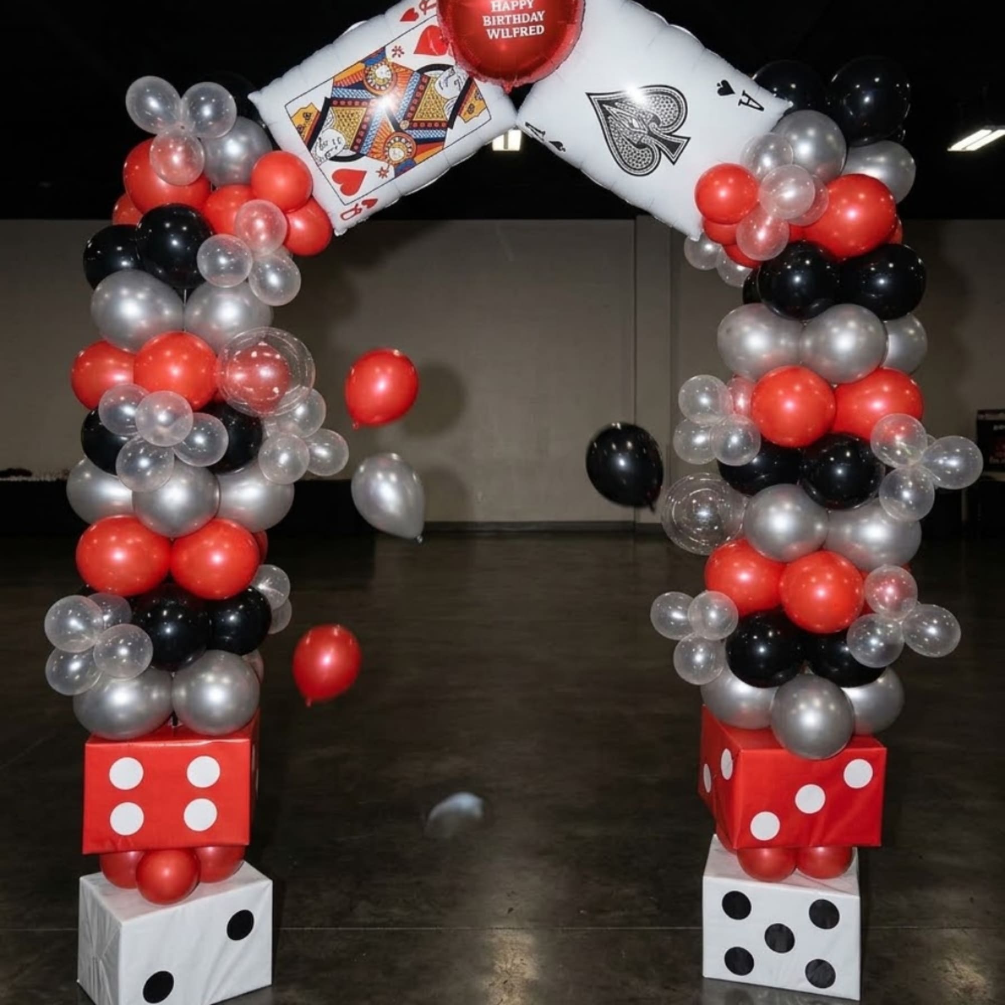 Balloon arch with playing-card and dice decorations