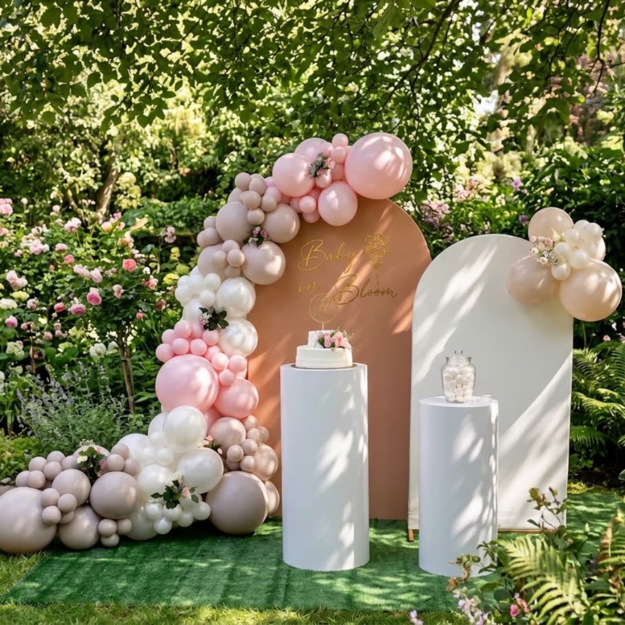 Pastel balloon arch with floral accents around a baby shower display