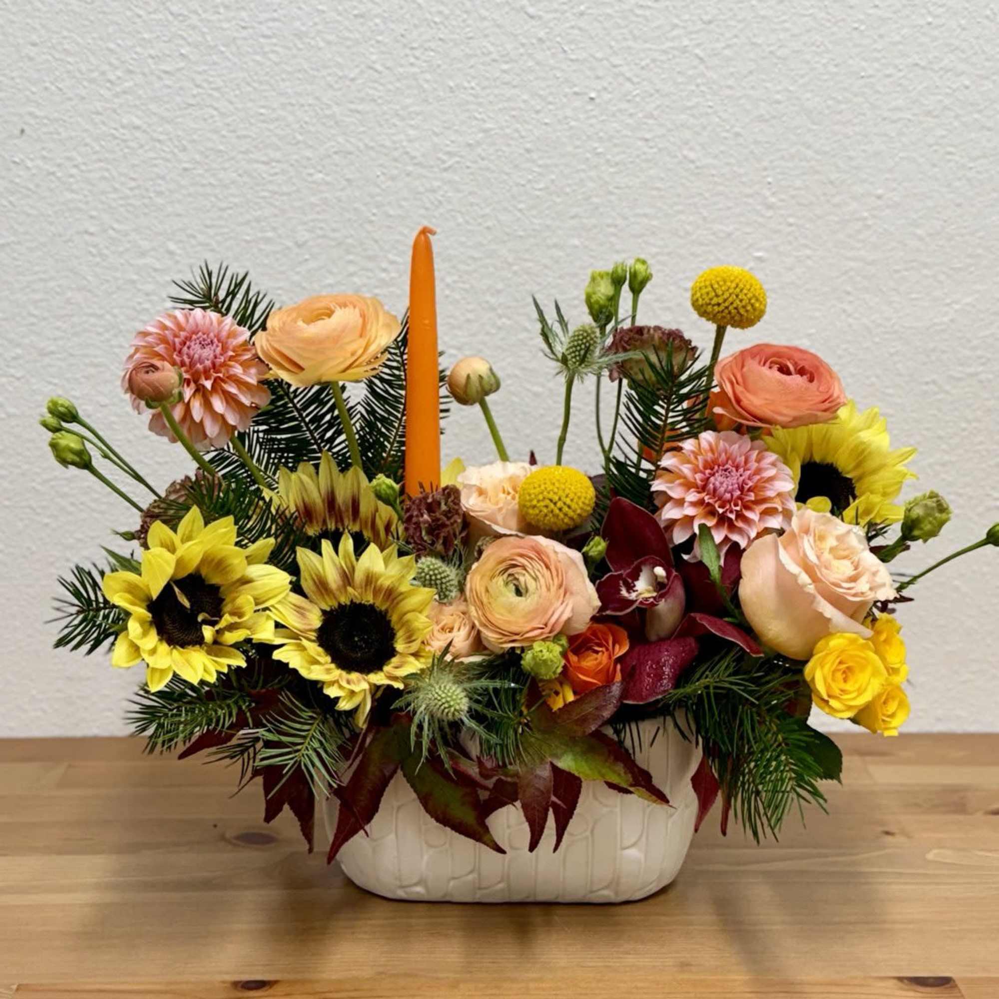 Mixed bouquet in a white ceramic container with sunflowers and roses