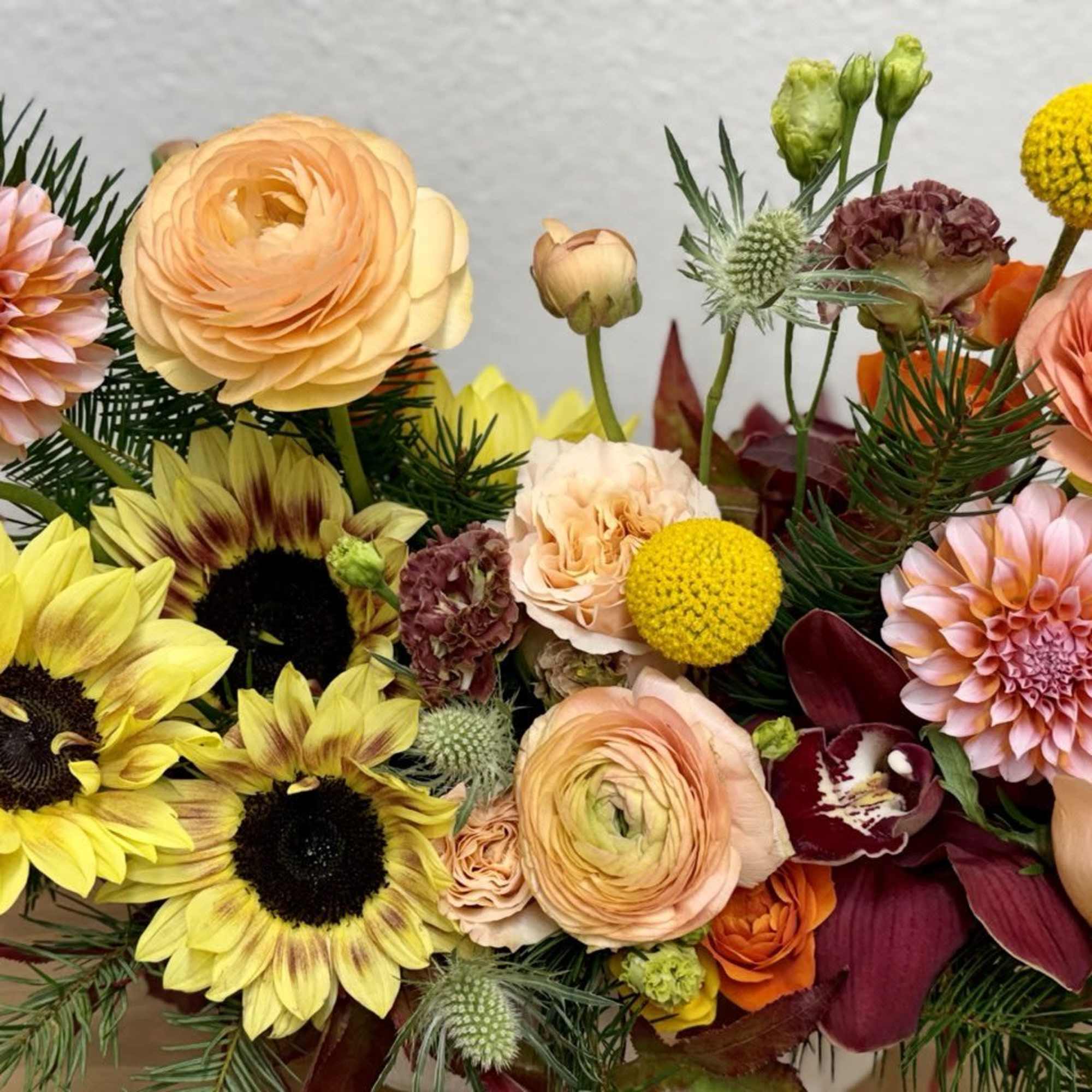 Mixed bouquet with sunflowers, ranunculus, dahlias, and roses