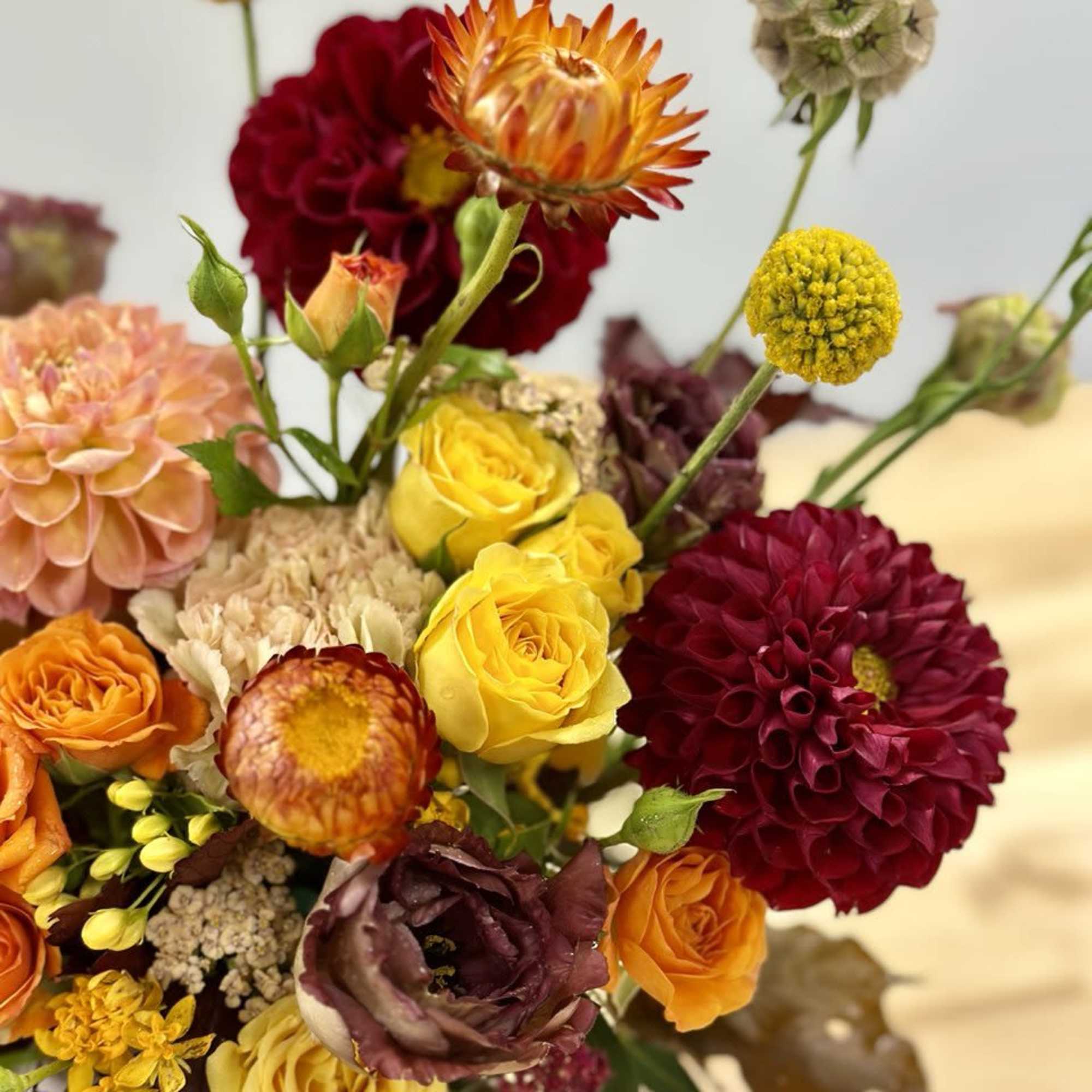 Mixed bouquet with yellow, orange, burgundy, and peach flowers