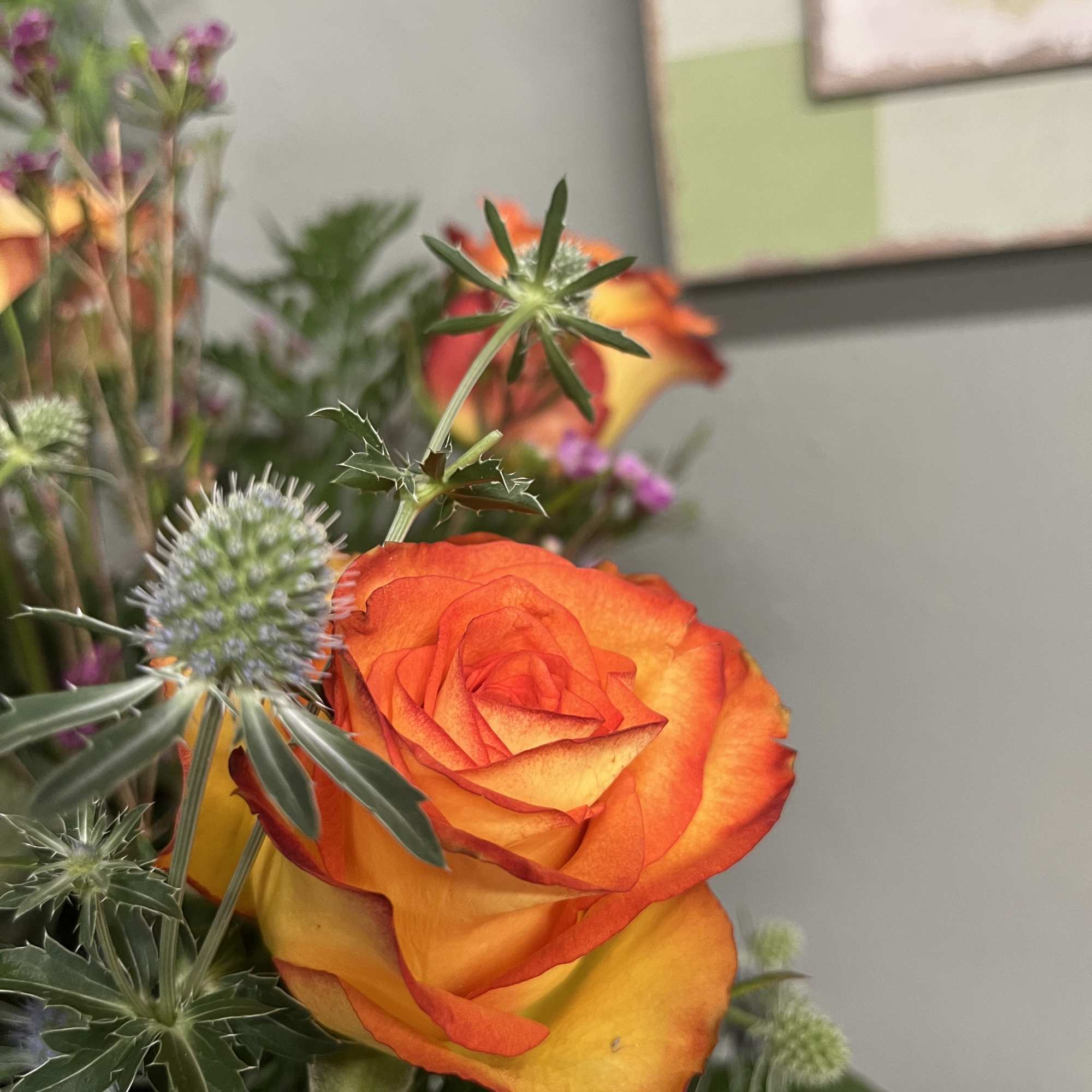 Orange and yellow rose in a mixed floral arrangement