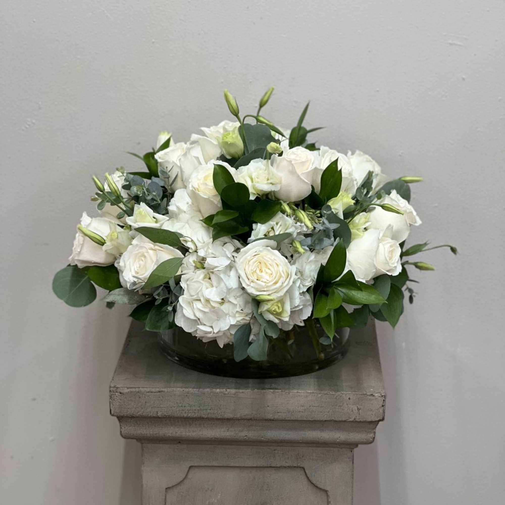 White rose and hydrangea arrangement in a low glass bowl