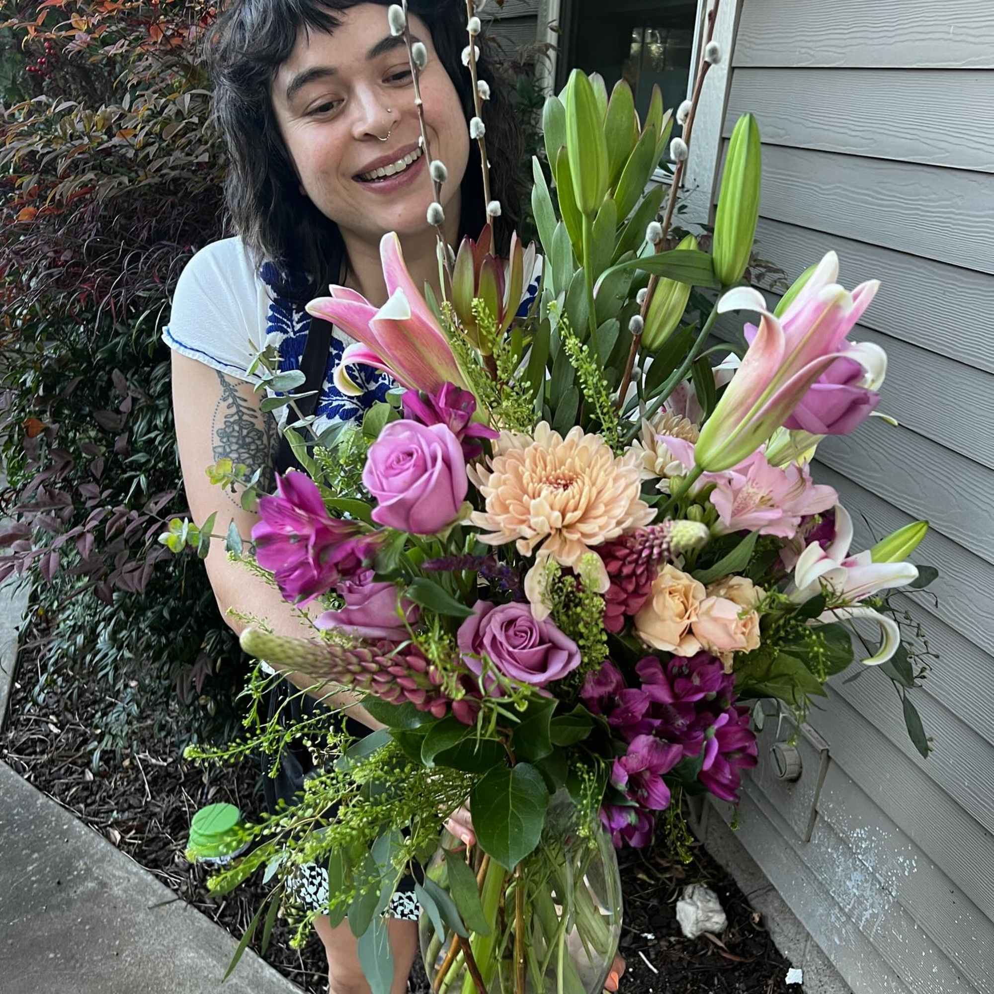 Woman holding a large mixed bouquet in a glass vase