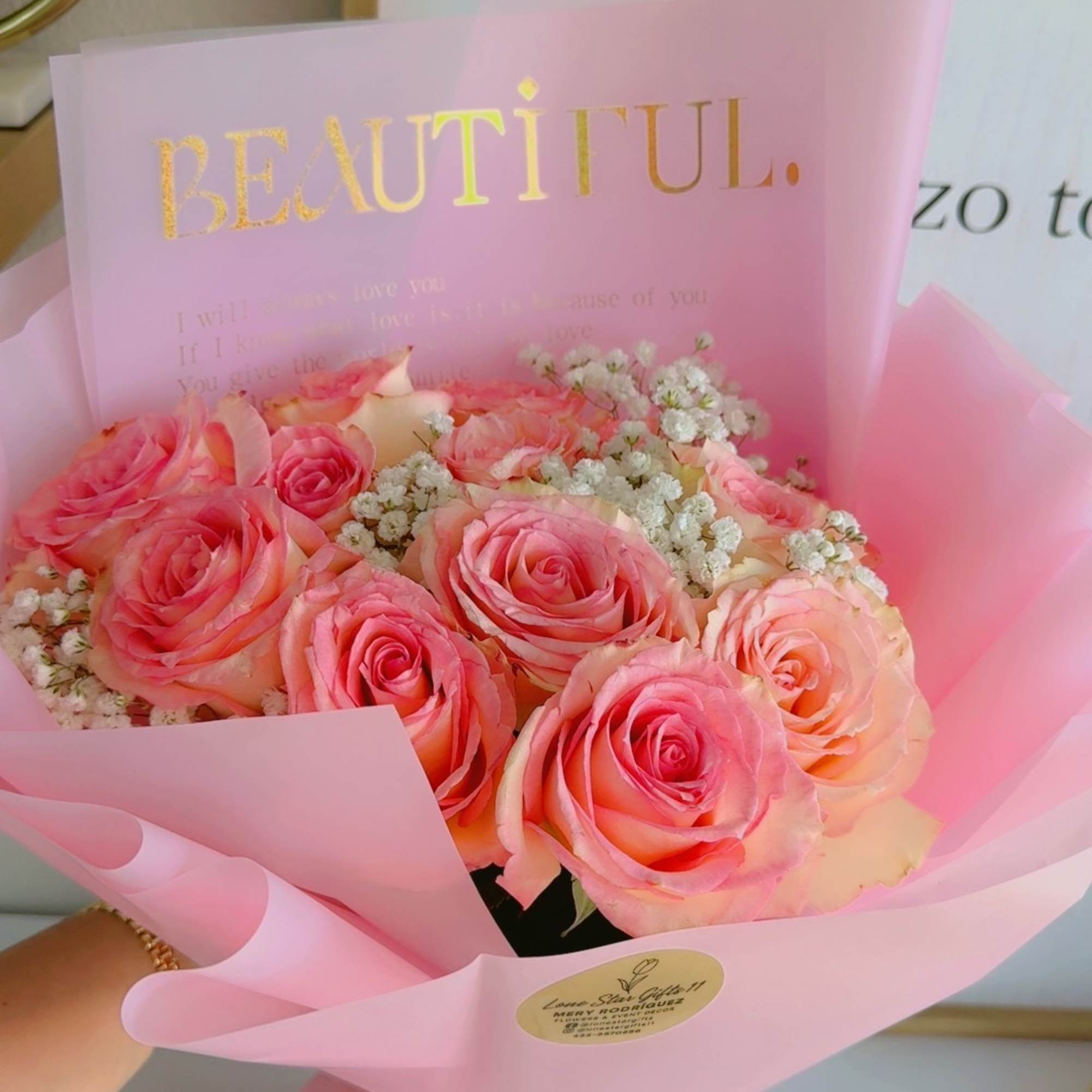 Pink rose bouquet wrapped in translucent paper with a gold "BEAUTIFUL" card
