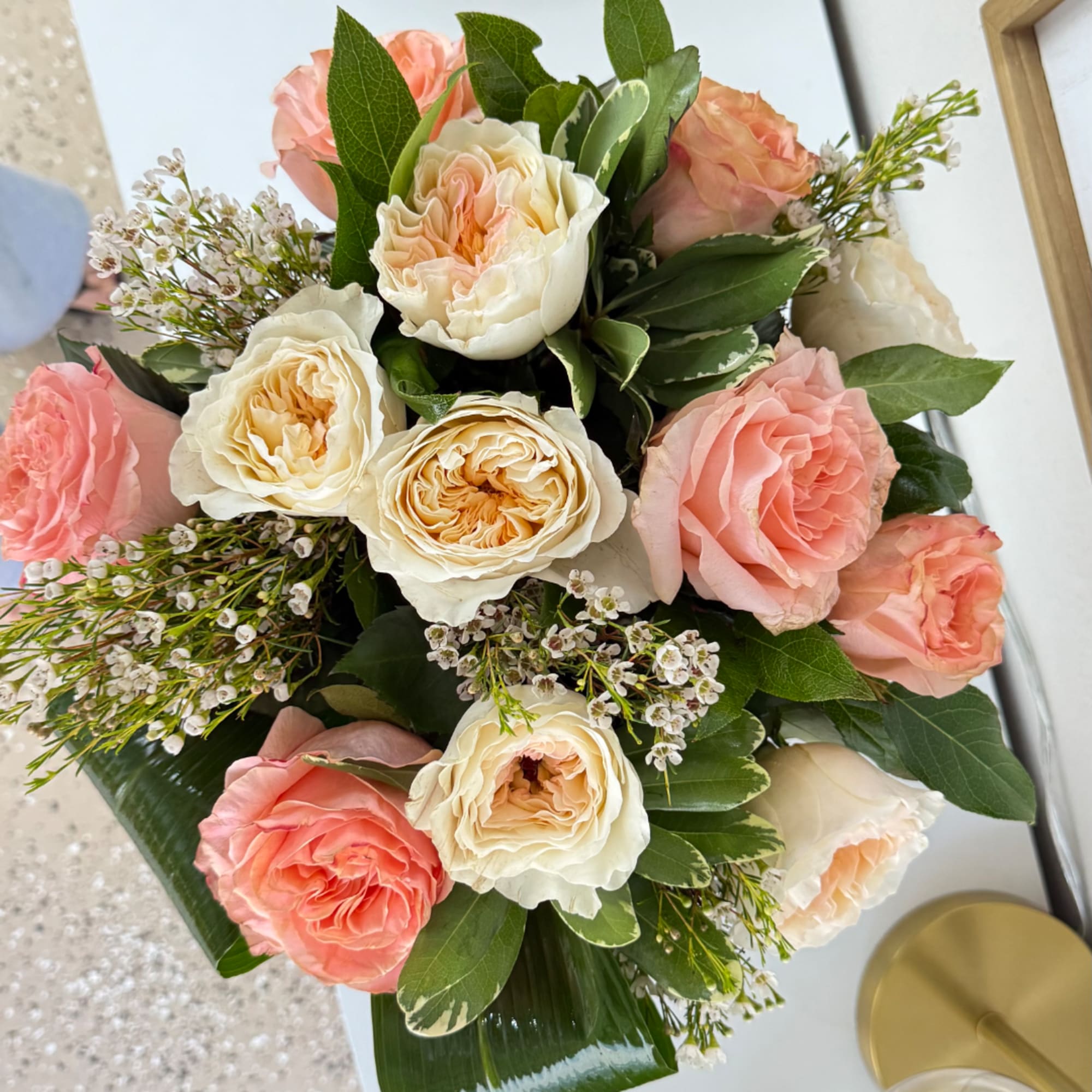 Bouquet of peach and cream roses with greenery