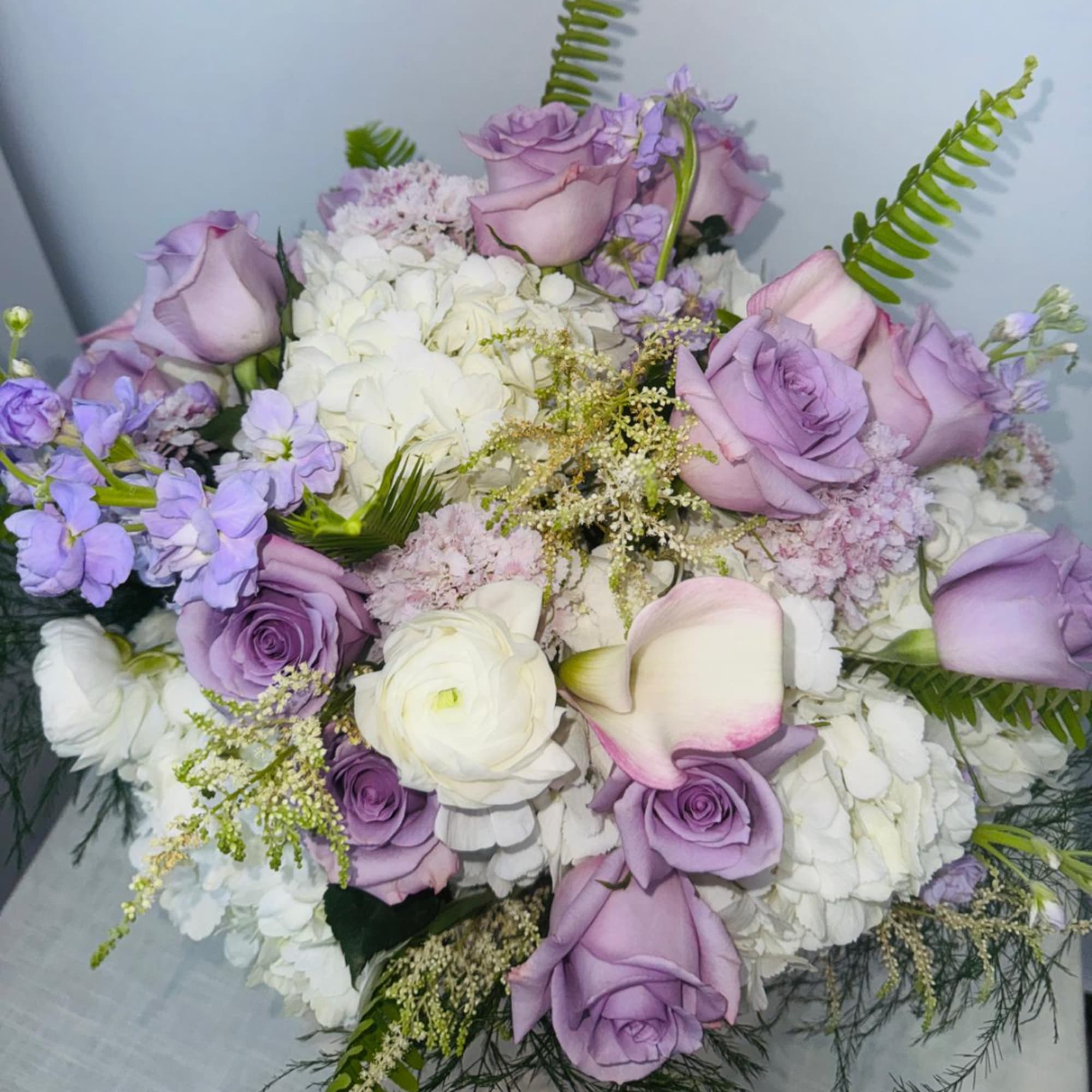 Lavender roses and white flowers arranged in a bouquet