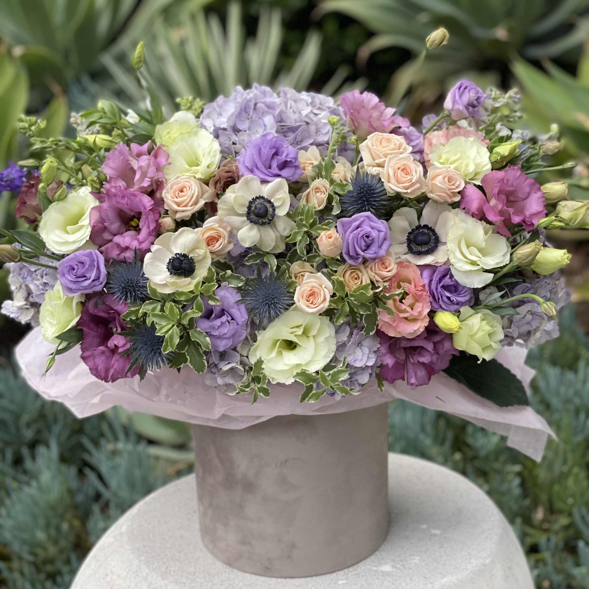 Mixed pastel bouquet in a beige hatbox-style container