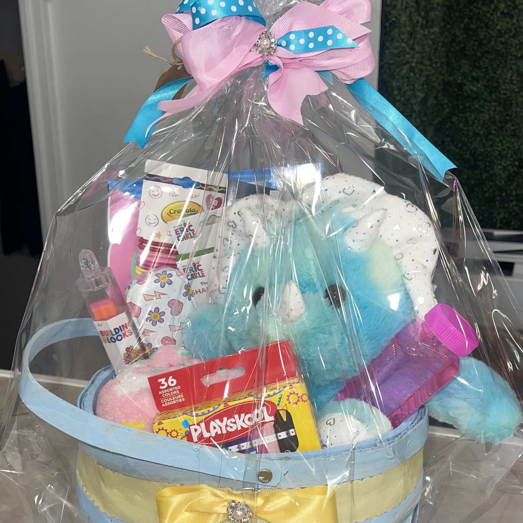 Gift basket with plush toys and crayons wrapped in clear plastic