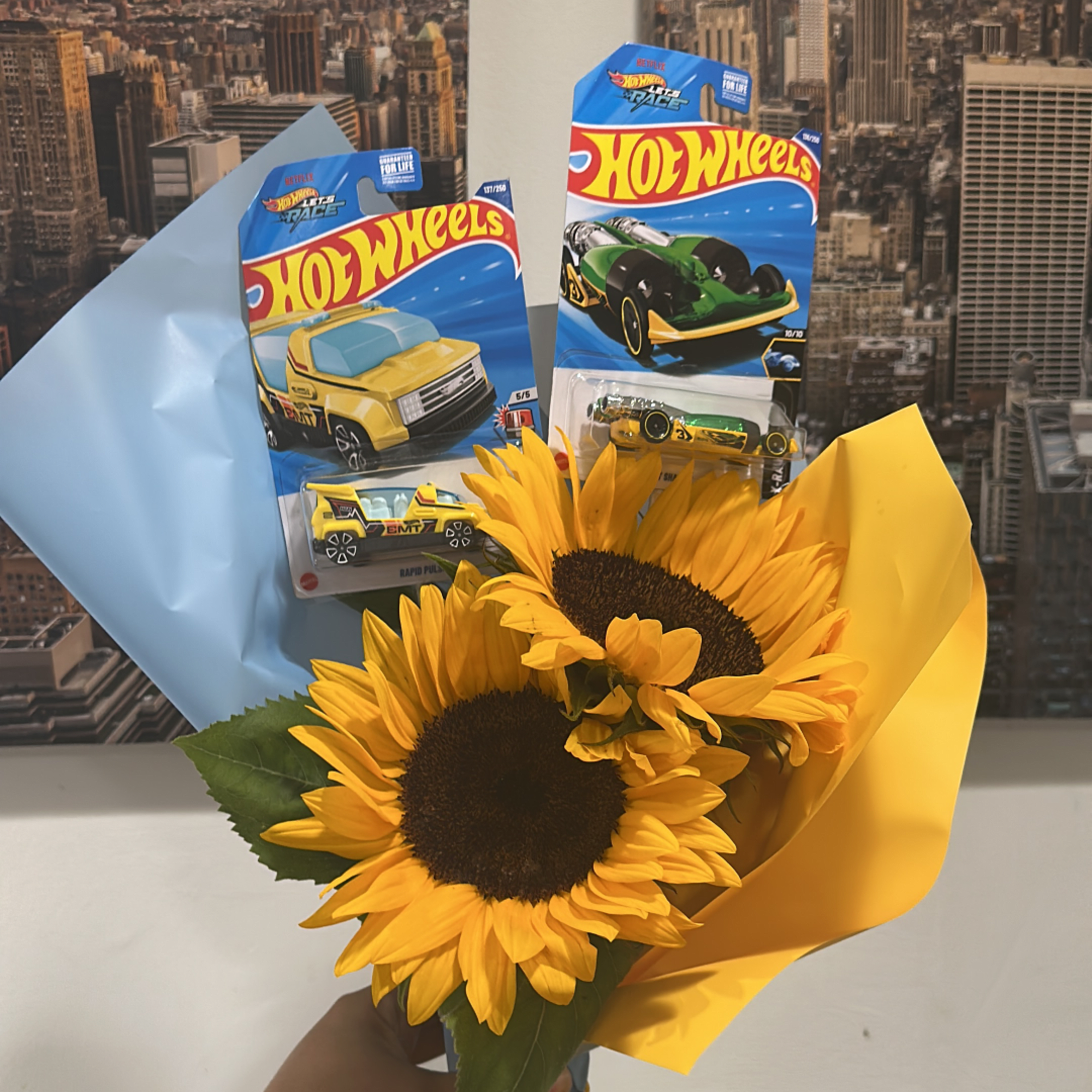 Sunflower bouquet with Hot Wheels toy cars in blue and yellow wrap