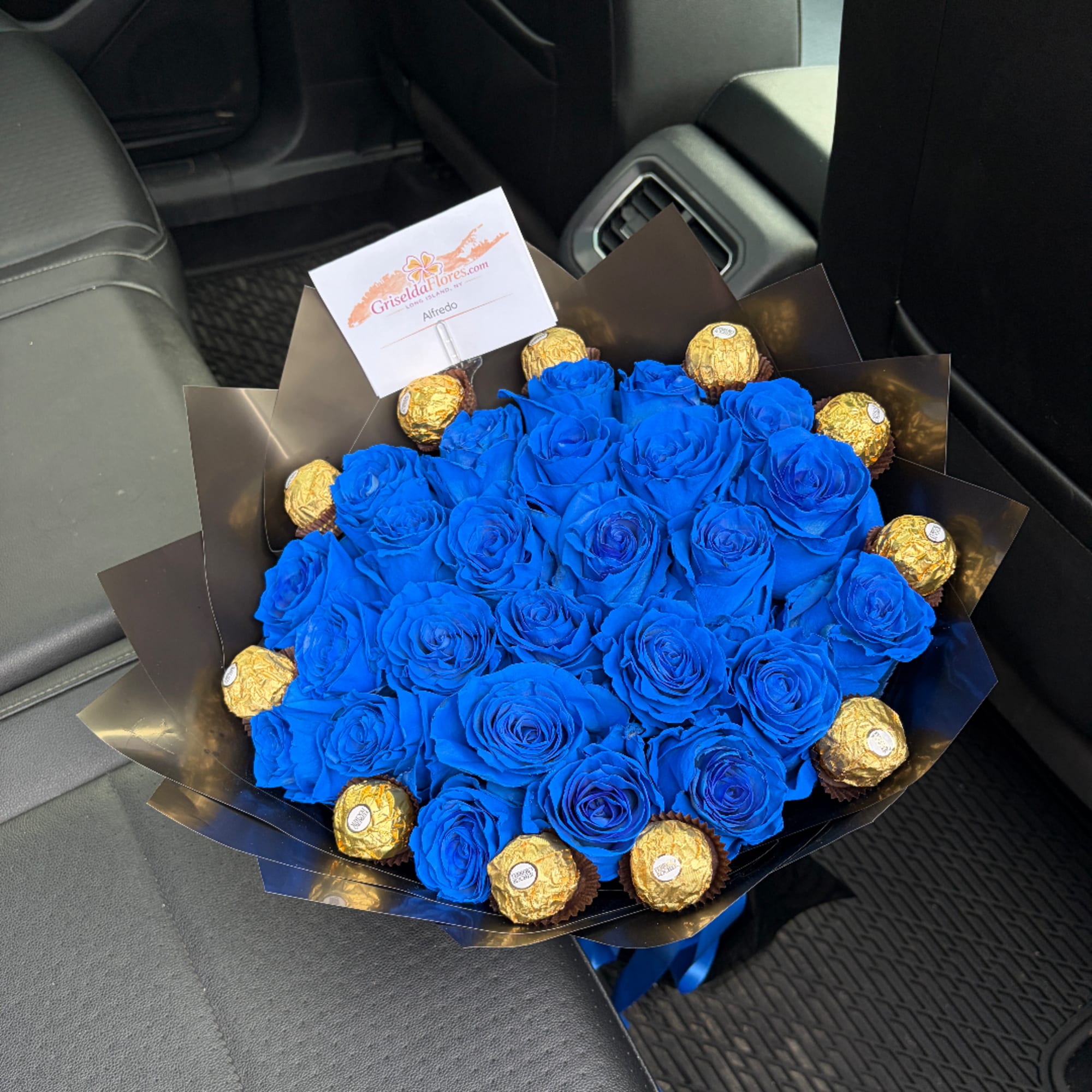 Blue rose bouquet with gold-wrapped chocolates in black paper