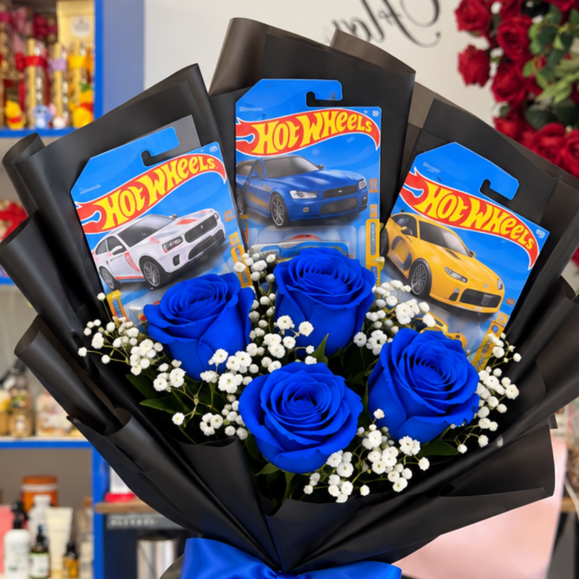 Blue roses with baby’s breath and Hot Wheels packages in black wrap
