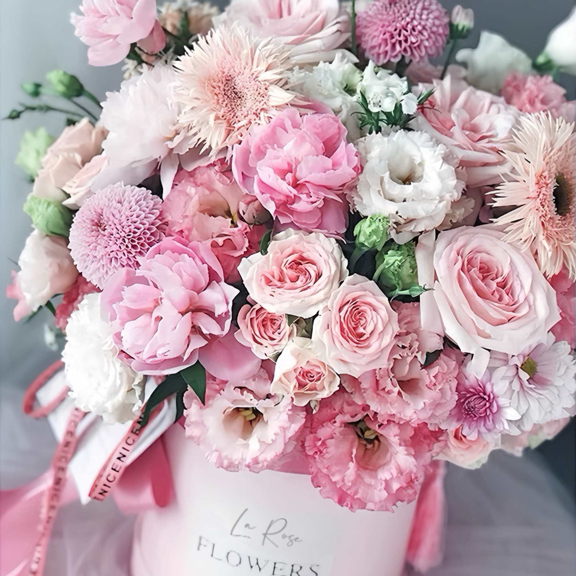 Pink and white bouquet in a round hatbox with ribbon