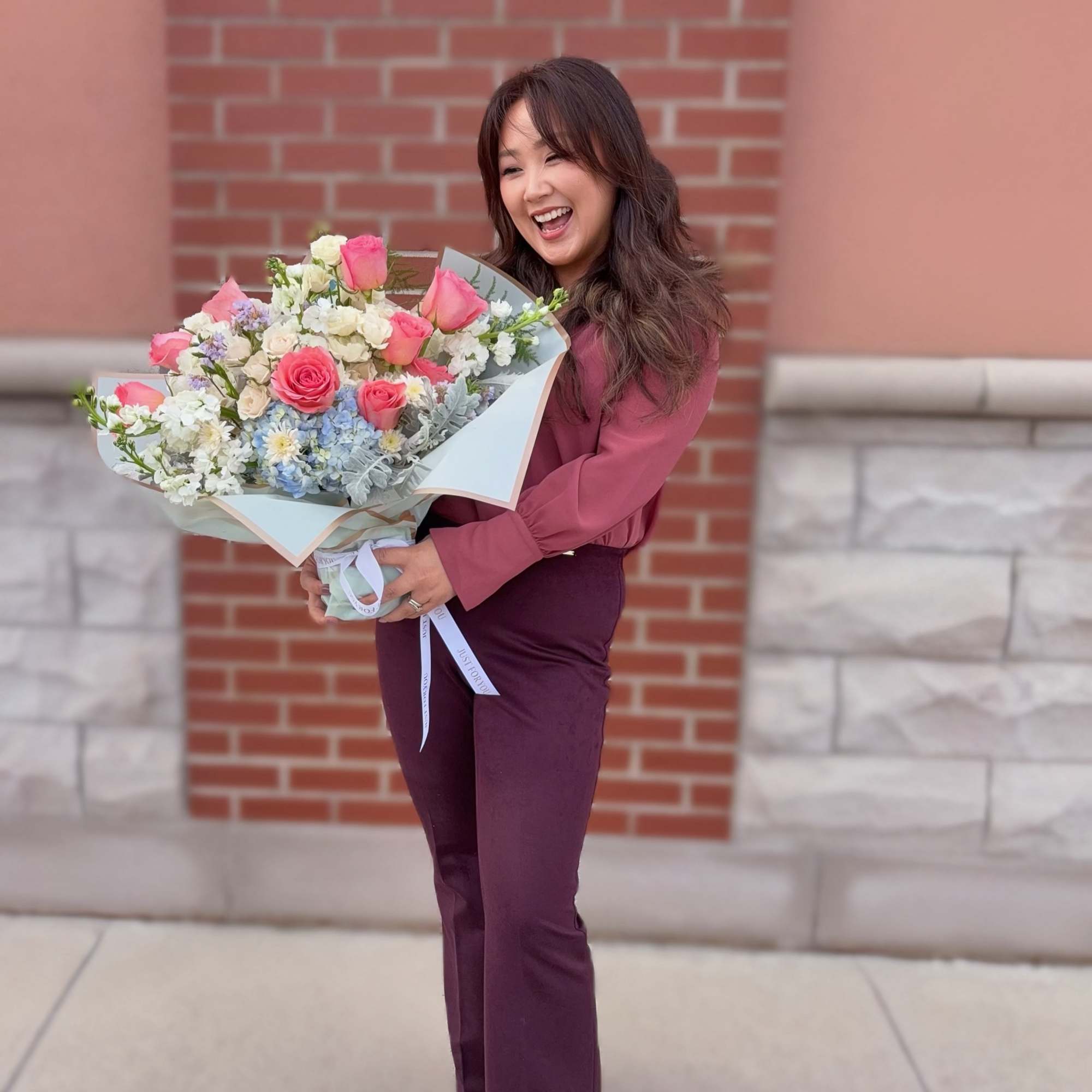Woman holding a large bouquet of pink and white flowers