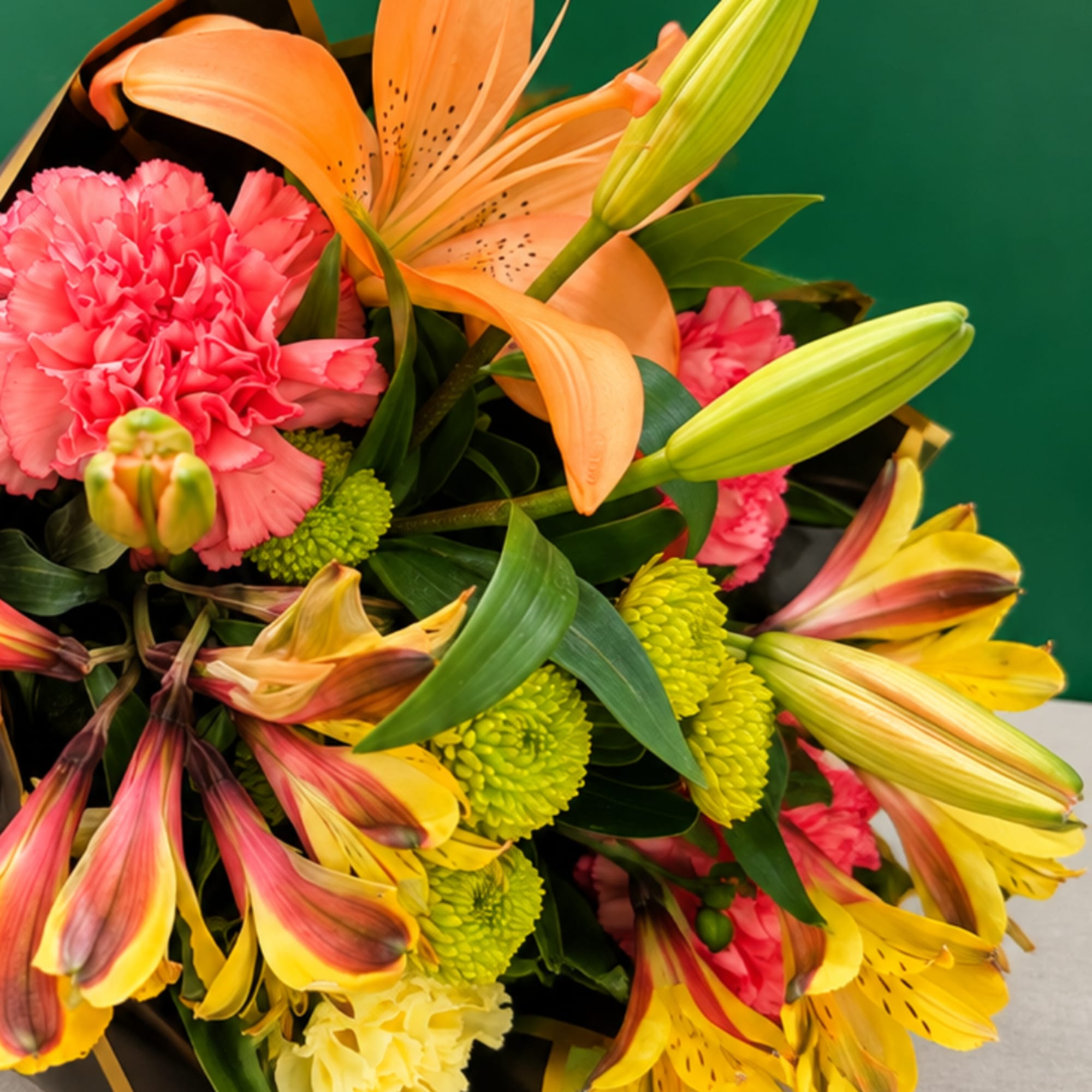 Bouquet of orange lilies, pink carnations, and yellow alstroemeria