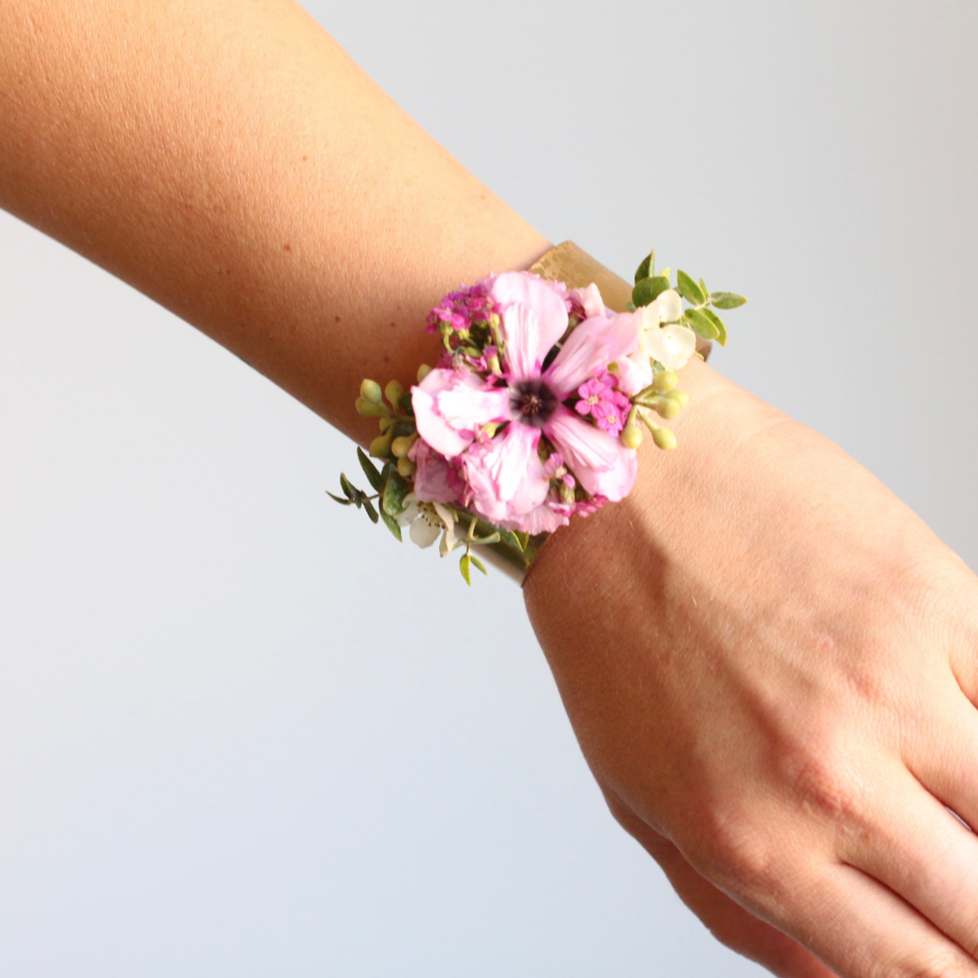 Pink floral wrist corsage on a person's wrist
