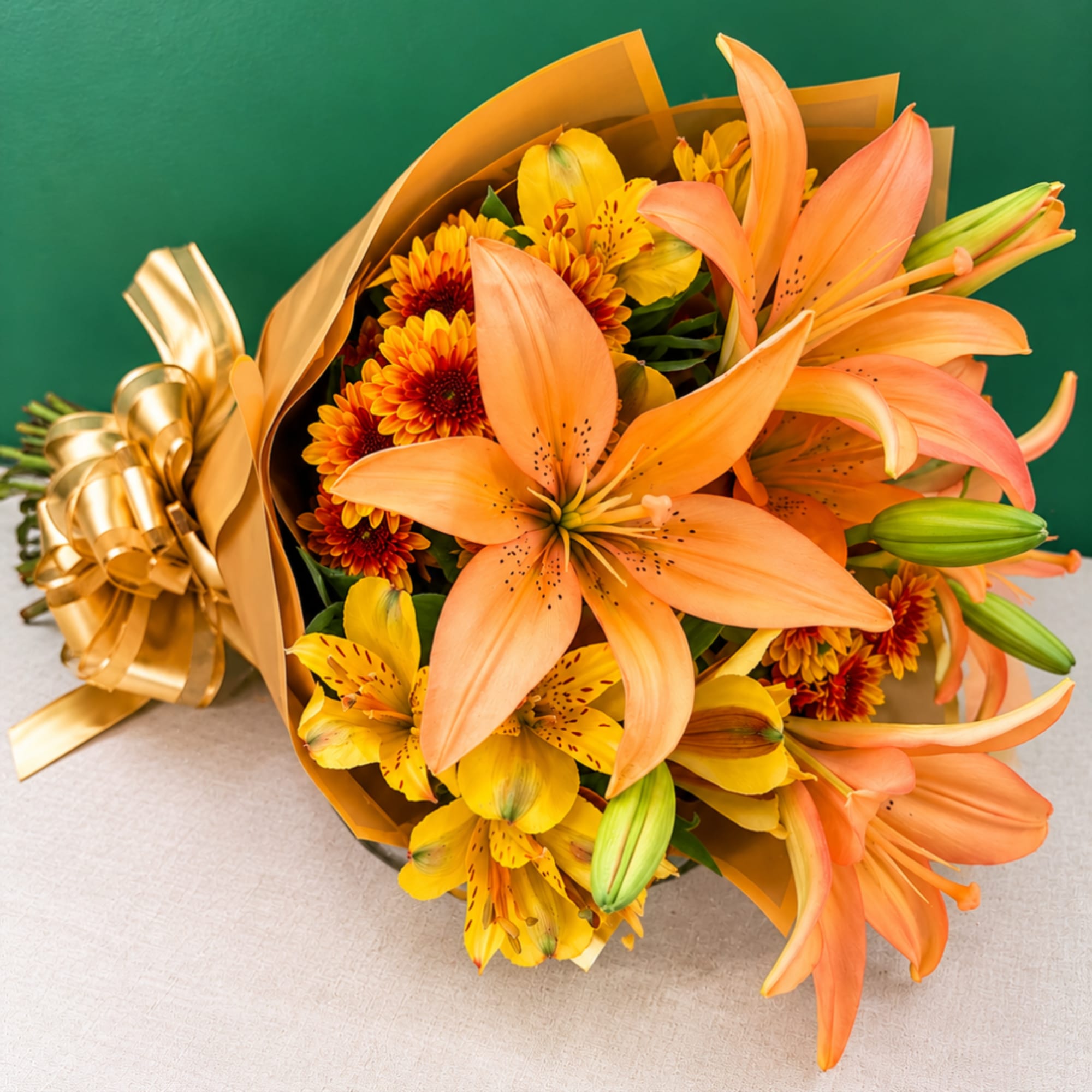 Bouquet of orange lilies and yellow alstroemeria wrapped in gold paper