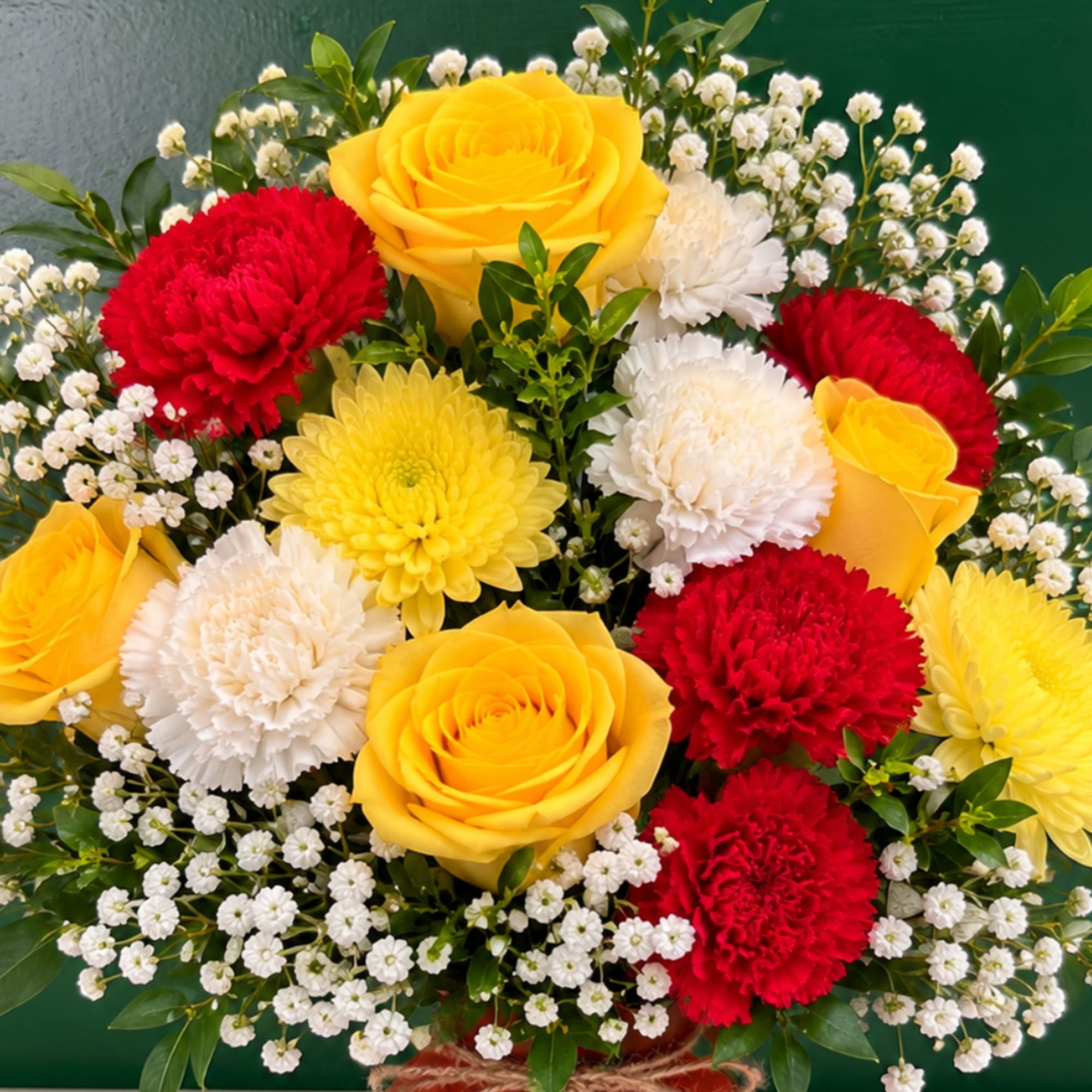 Bouquet of yellow roses, red and white carnations, and small white filler flowers