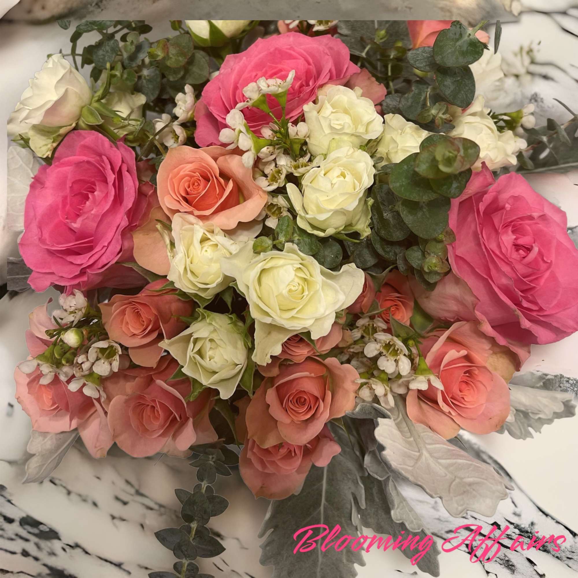 Bouquet of pink, peach, and white roses with eucalyptus