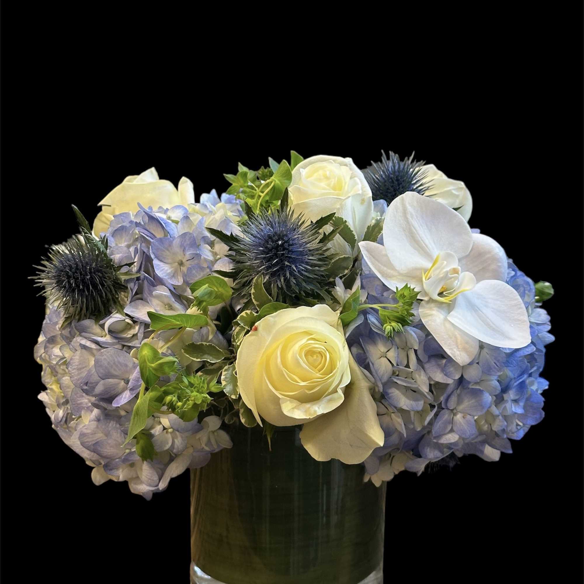 Blue hydrangeas with white roses and orchids in a glass vase, photo 2 of 2