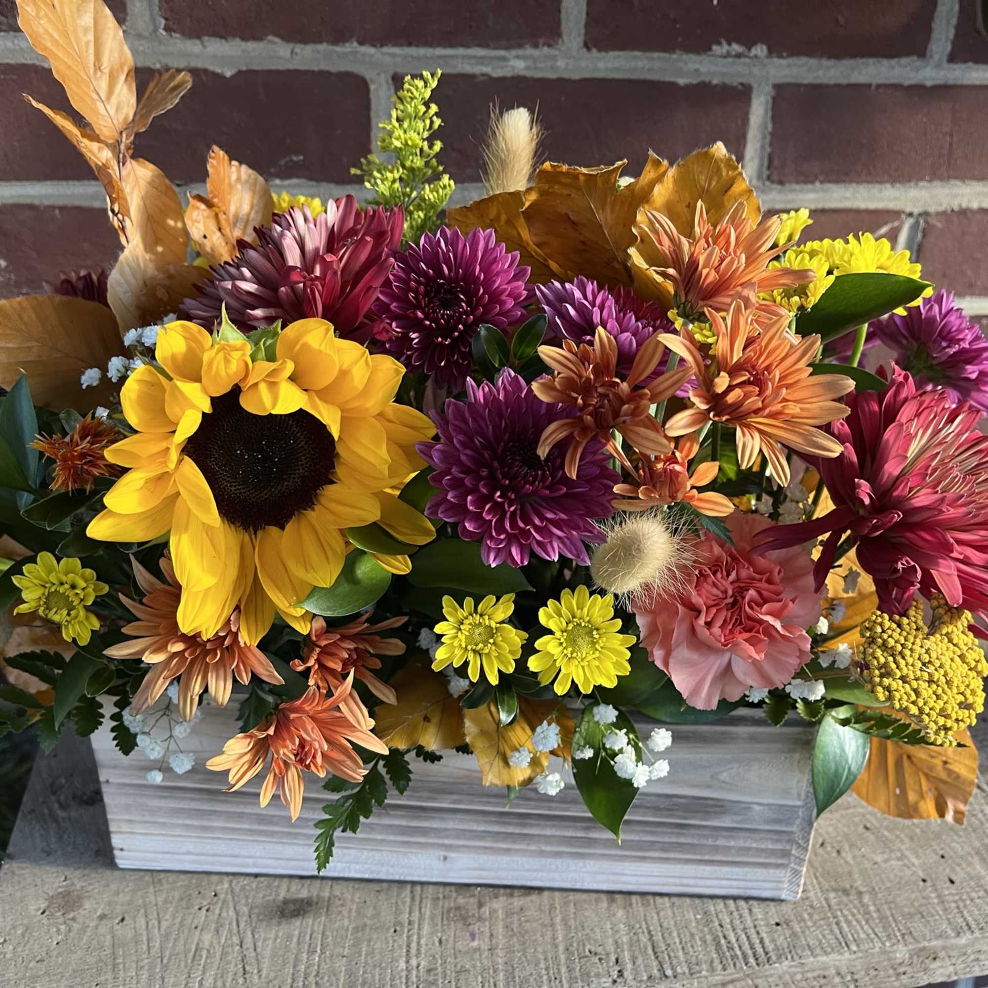 Mixed autumn flower arrangement in a white wooden box