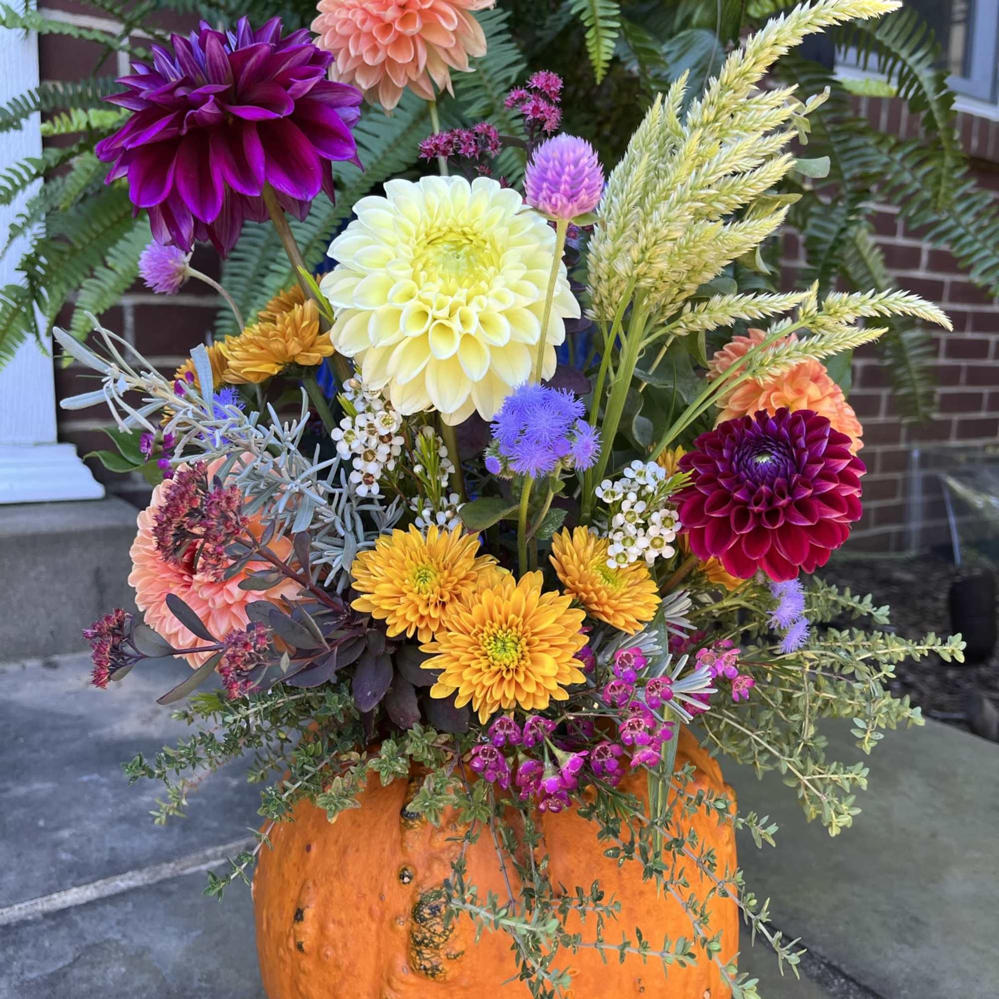 Colorful mixed flower arrangement in a carved orange pumpkin container
