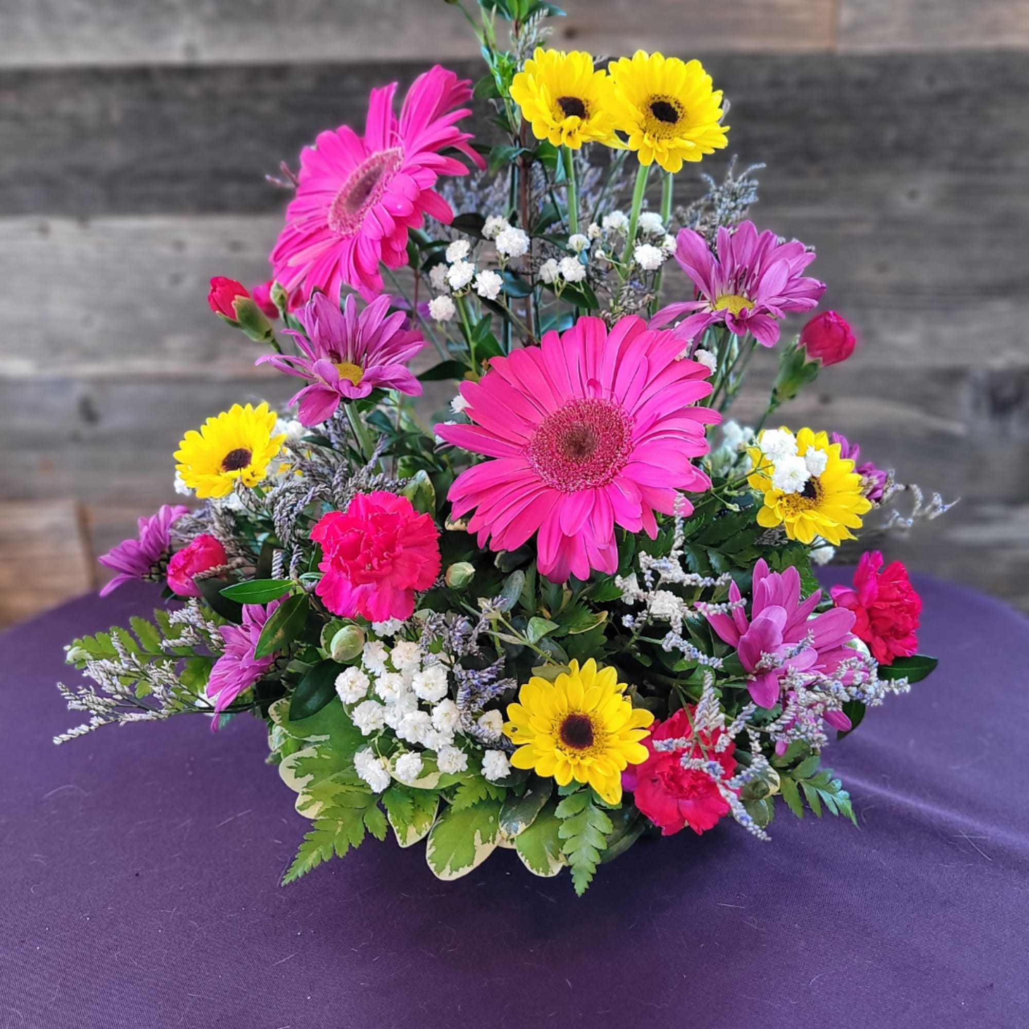 Bright mixed bouquet with pink gerbera daisies, yellow daisies, and carnations