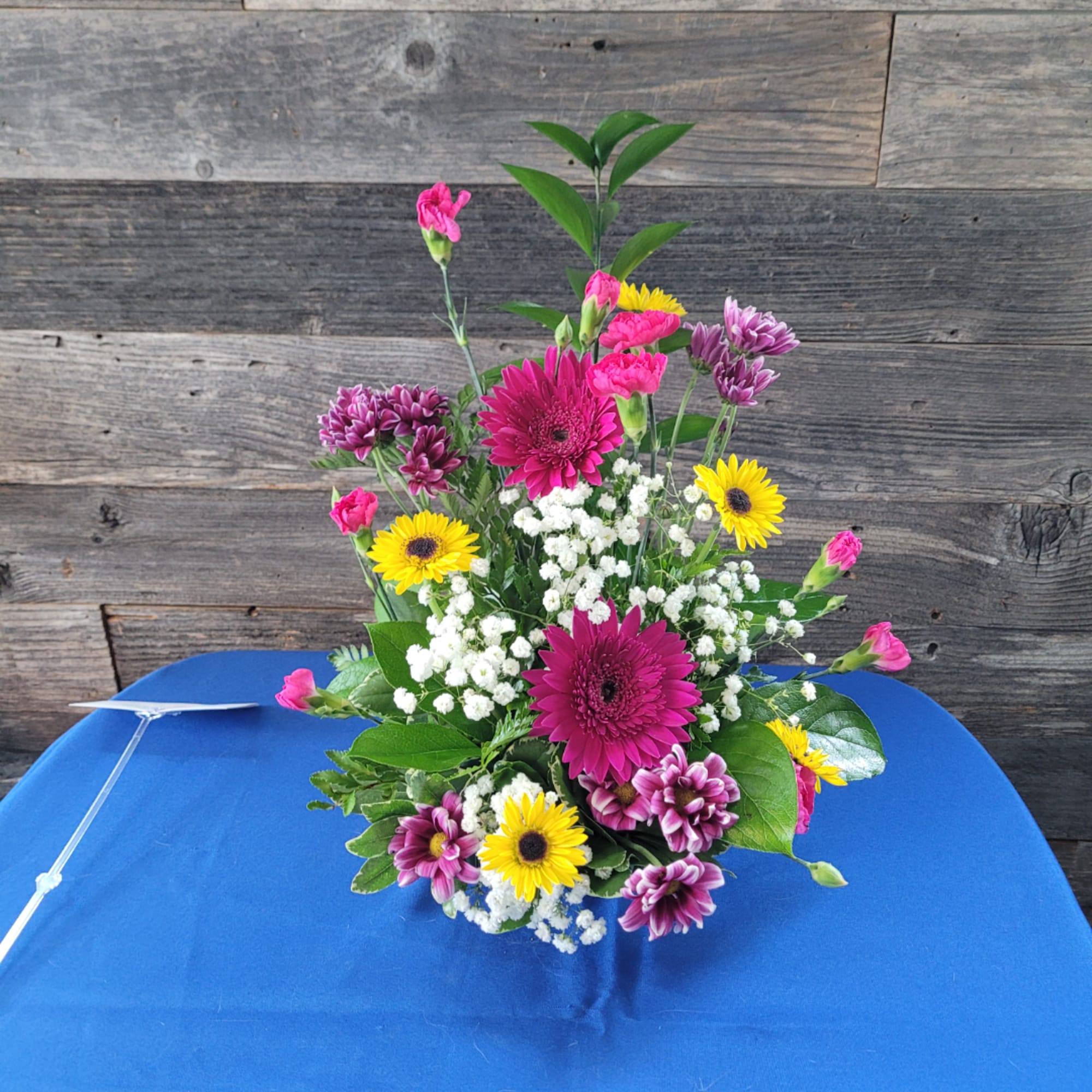 Mixed bouquet with pink, yellow, and purple flowers in a vase