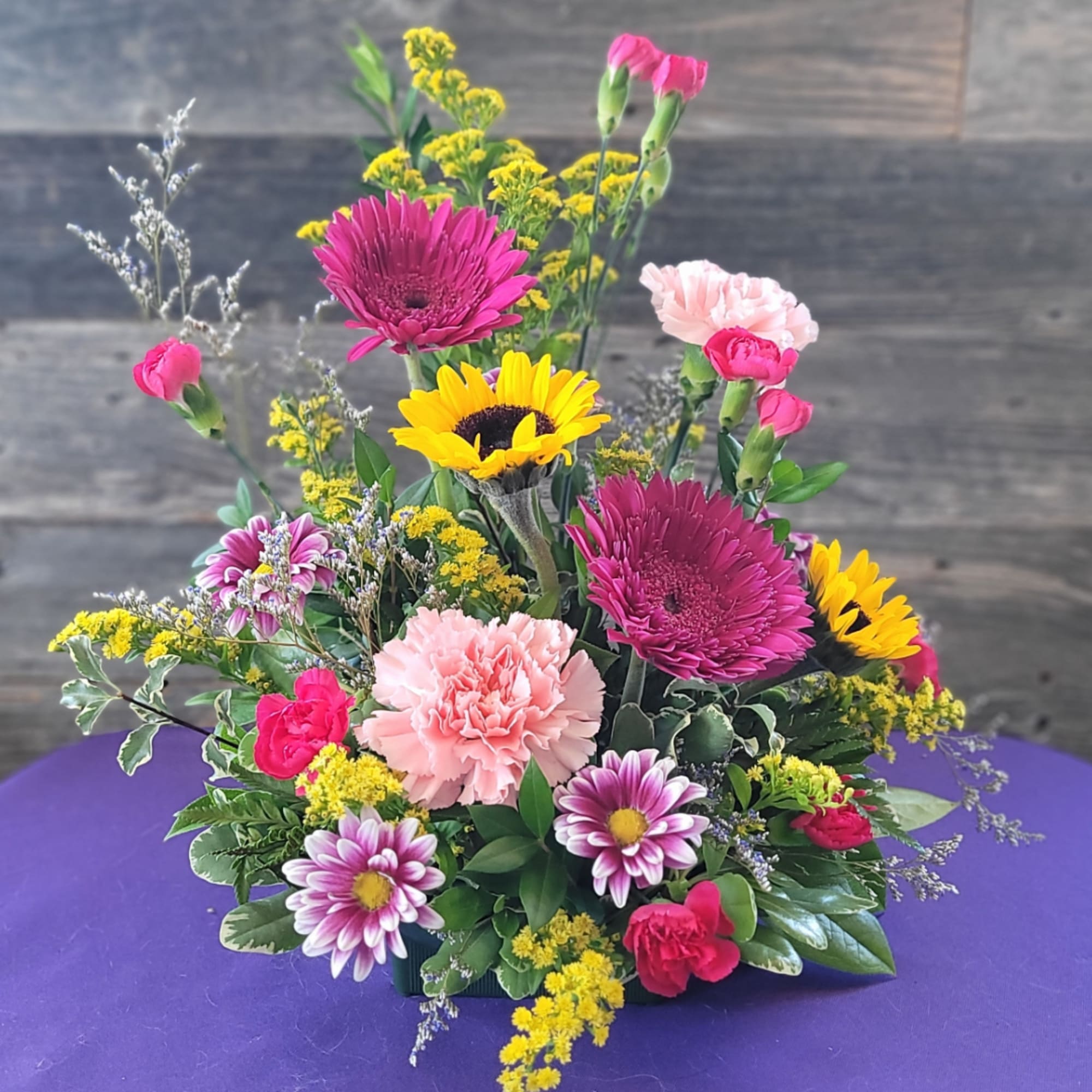 Mixed bouquet with gerbera daisies, carnations, and yellow filler flowers