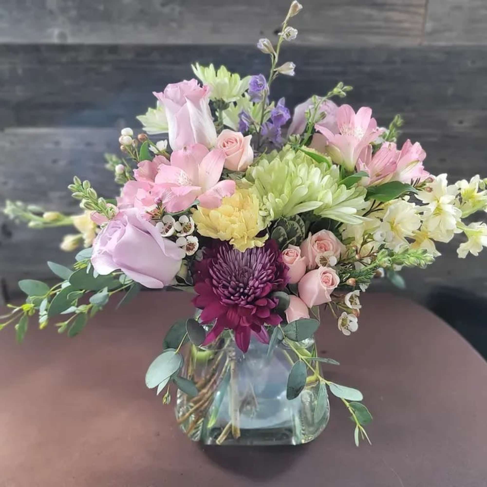 A soft parade of pastel roses, carnations and chrysanthemums greets the recipient