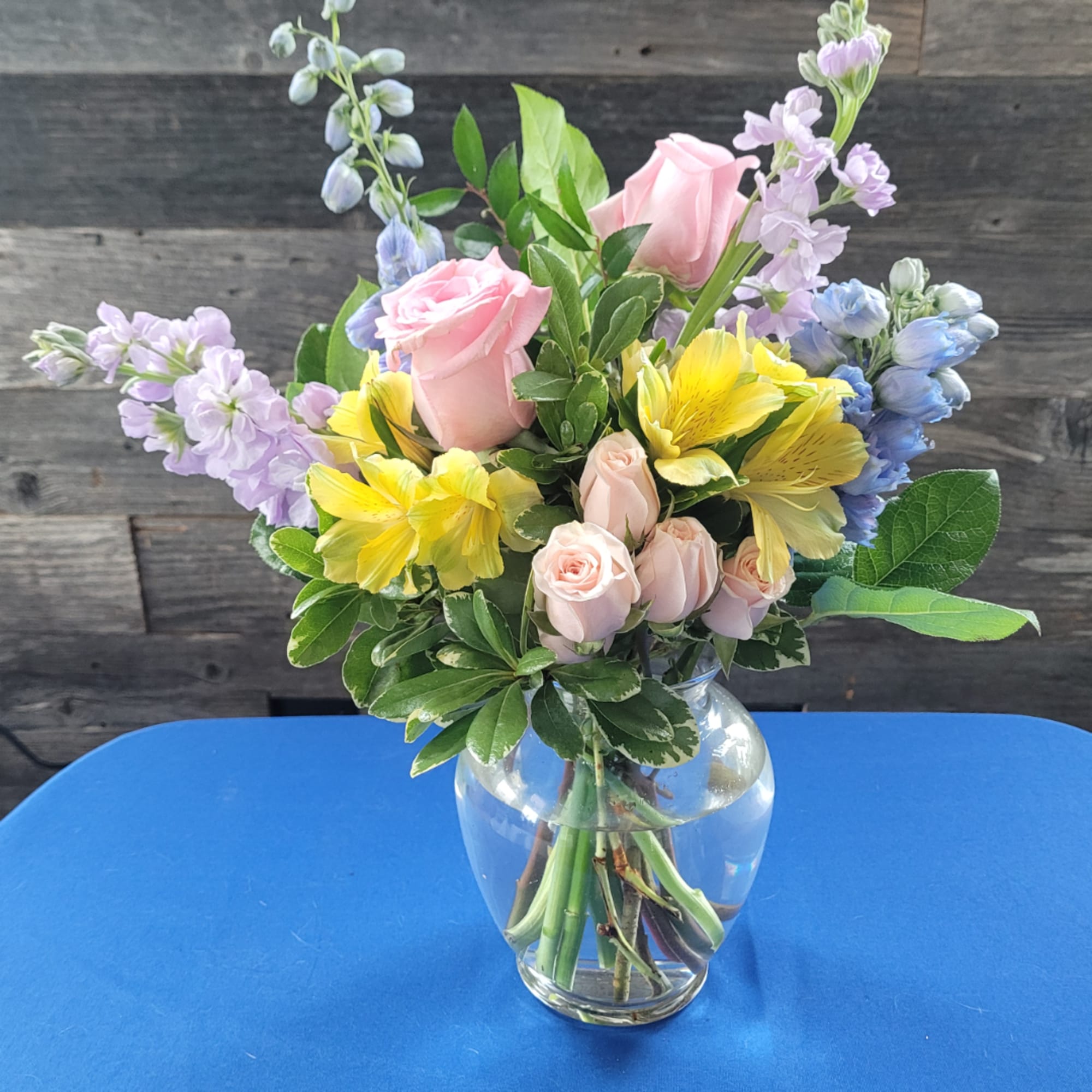 Pink roses and yellow alstroemeria in a clear glass vase