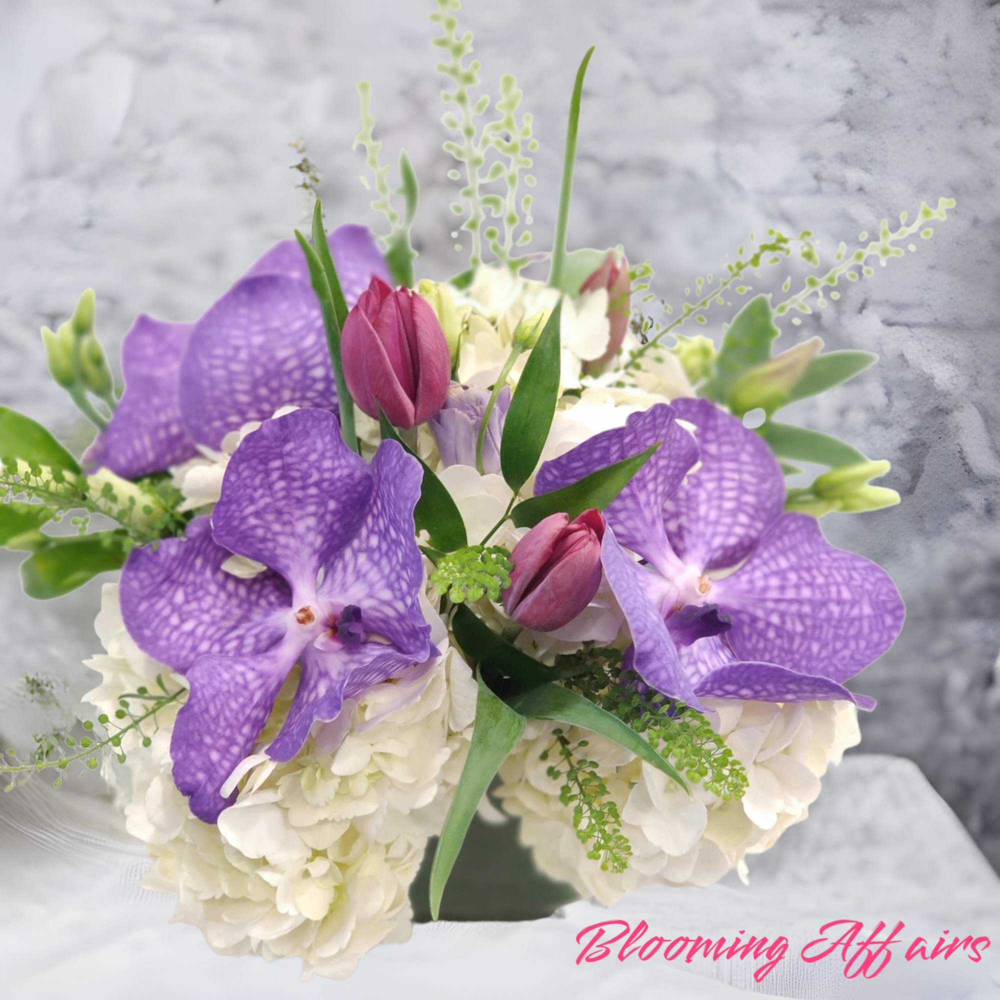 Purple orchids and white hydrangeas in a compact bouquet
