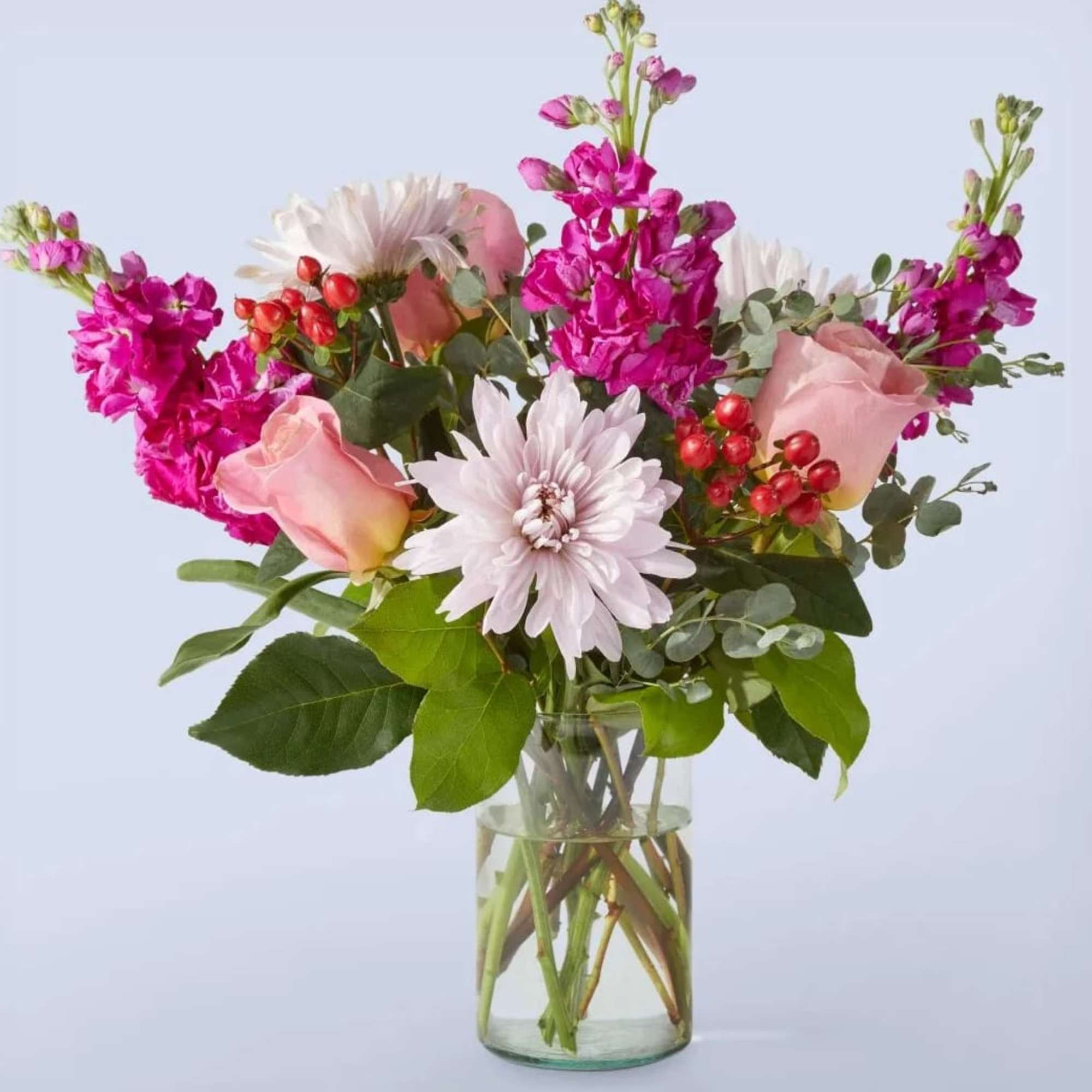 Pink roses and white daisies in a clear glass vase