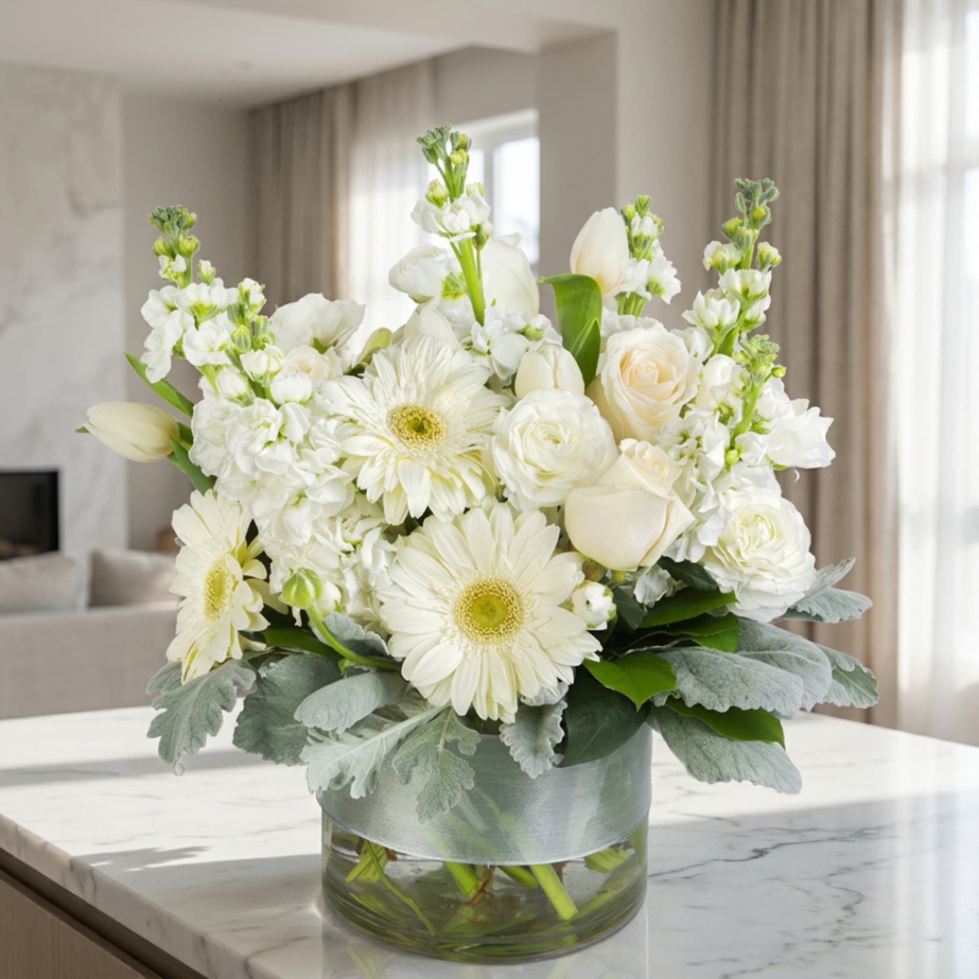 White floral arrangement in a clear glass vase with a silver ribbon