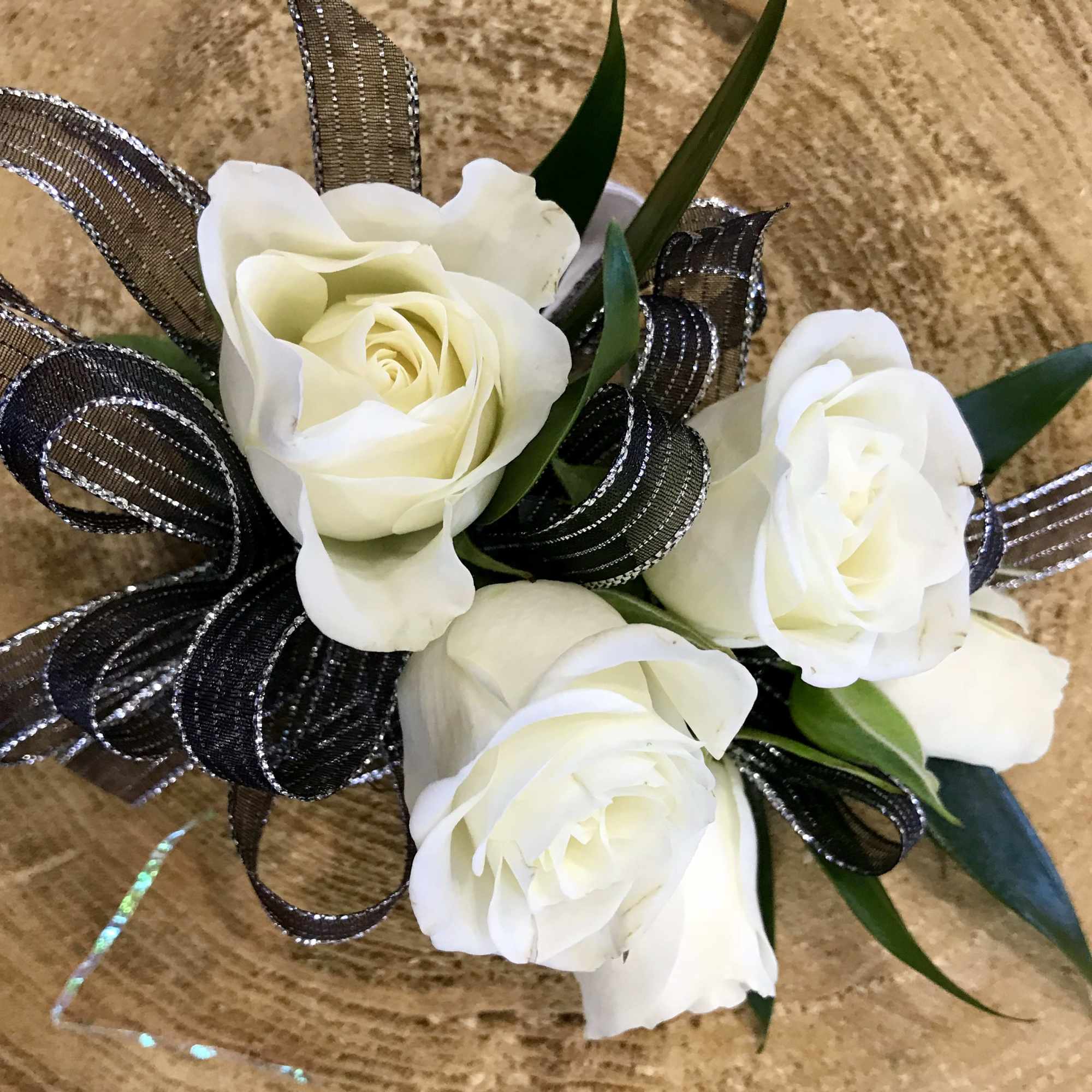 Small bouquet of white roses with black ribbon loops
