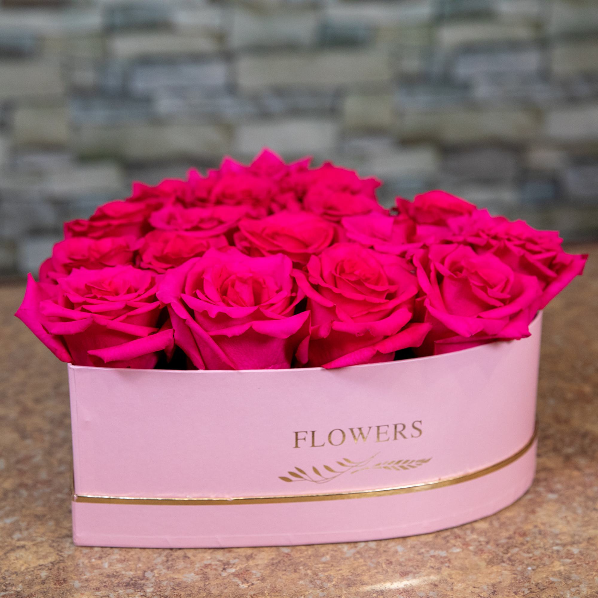 Hot pink roses arranged in a pink heart-shaped box