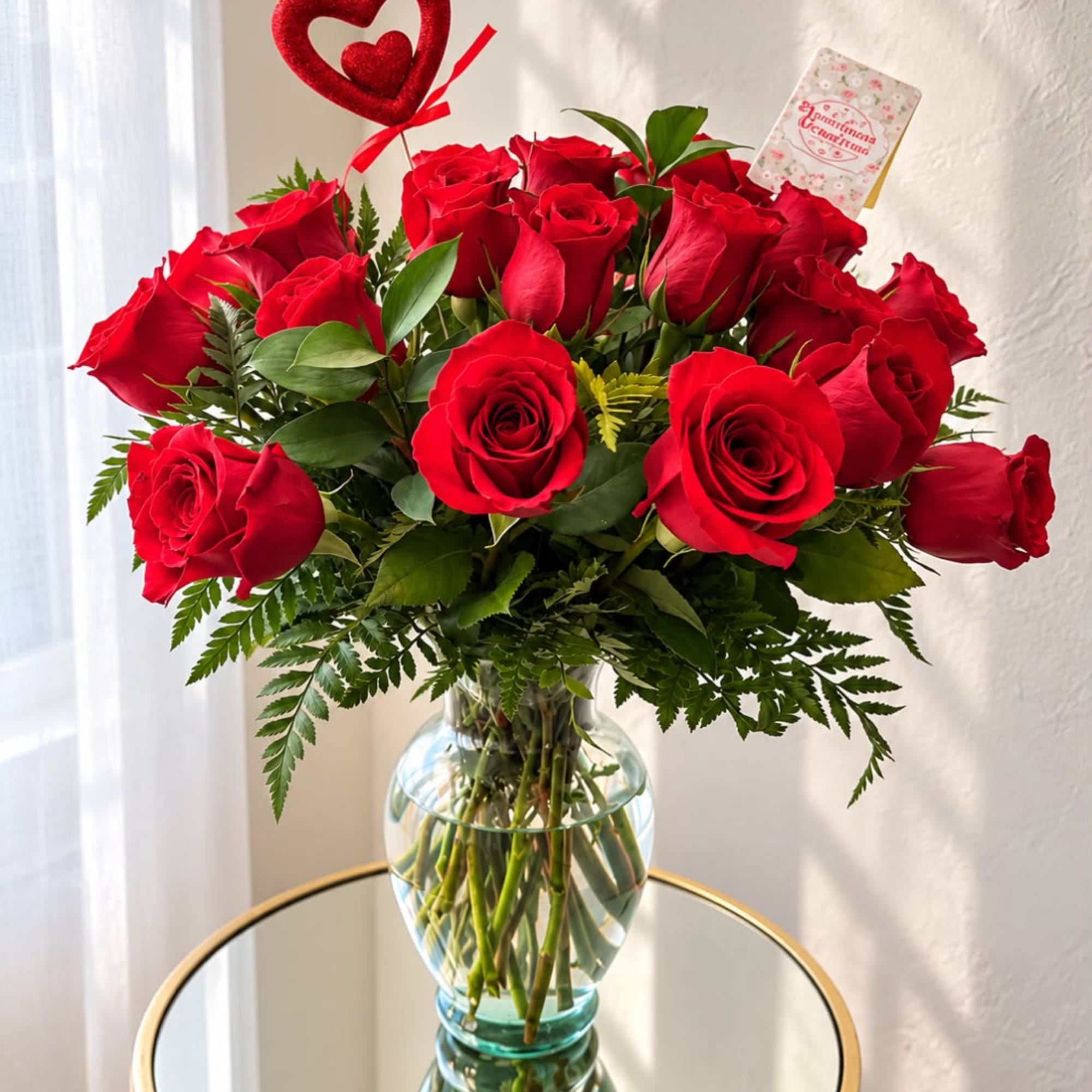 Bouquet of red roses in a clear glass vase with a heart pick
