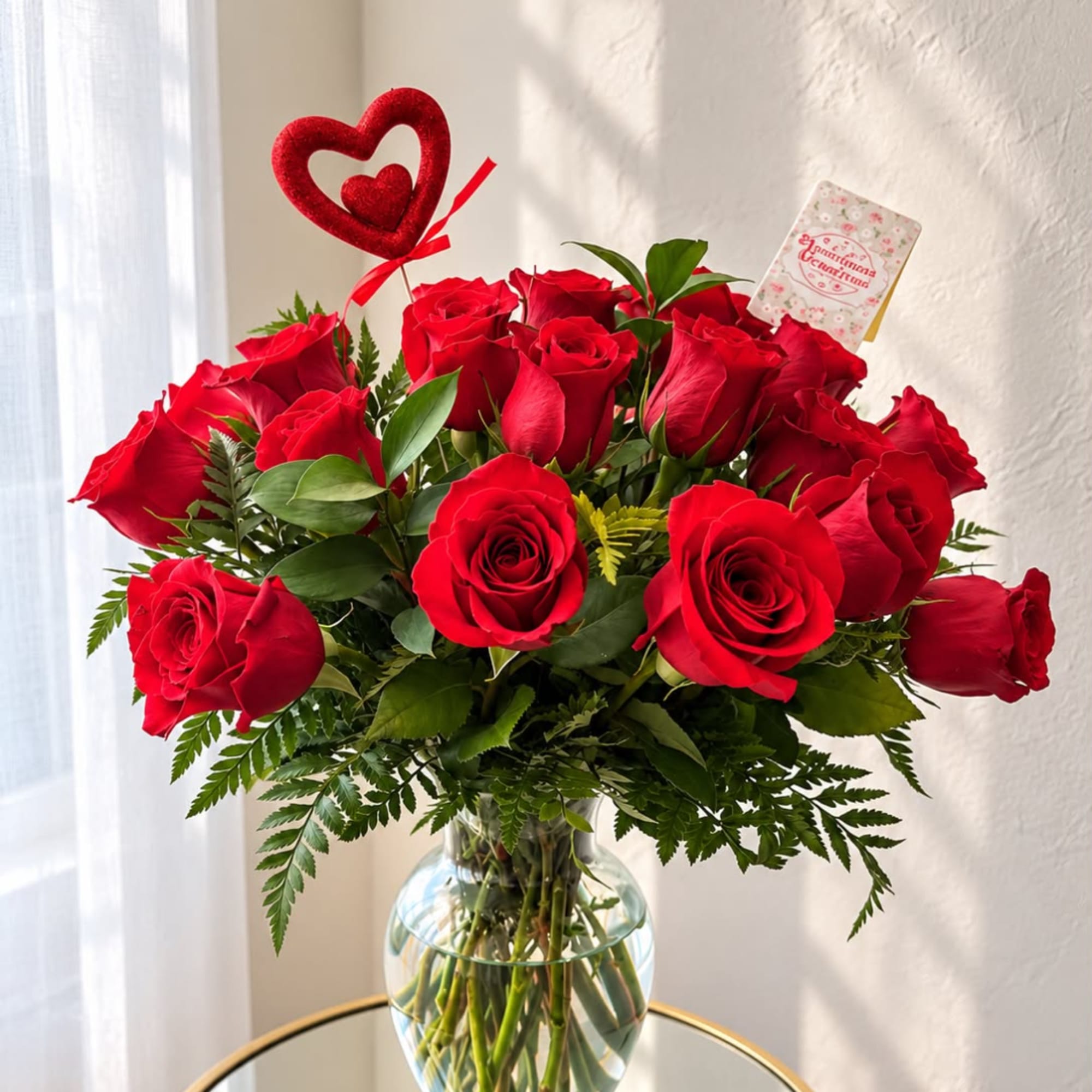Red roses in a glass vase with a heart pick and card
