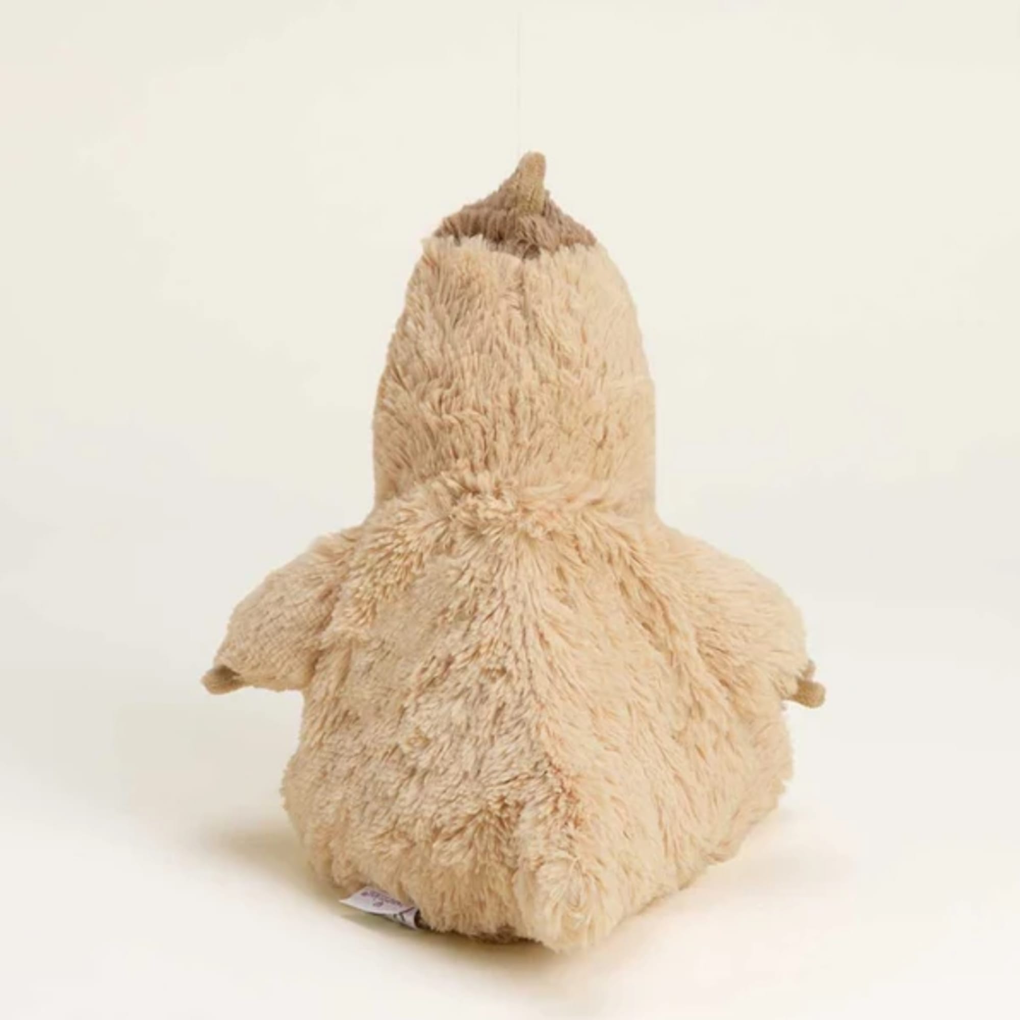 Plush penguin-shaped stuffed animal in beige fur on a plain background