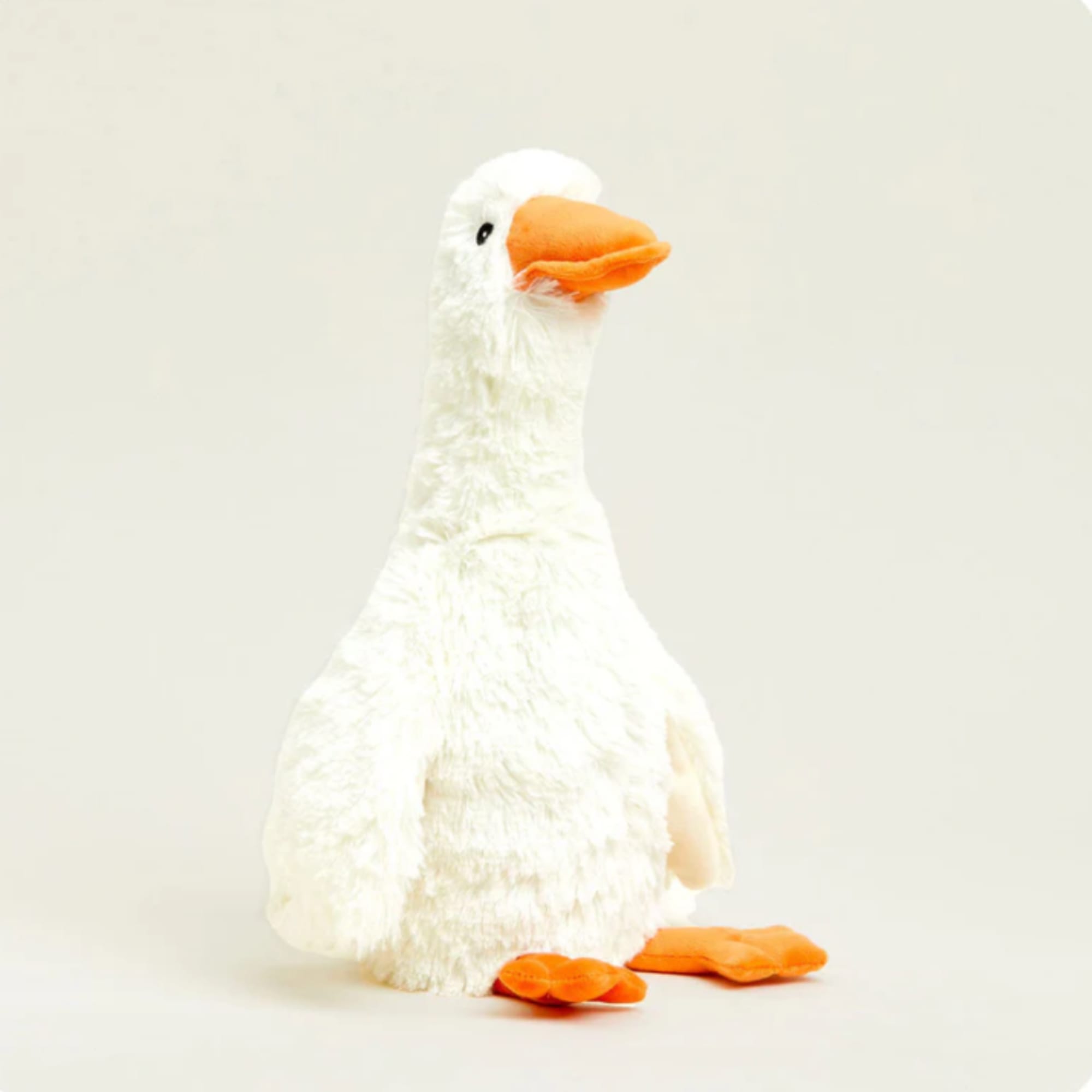 White plush duck with an orange beak and feet on a plain background