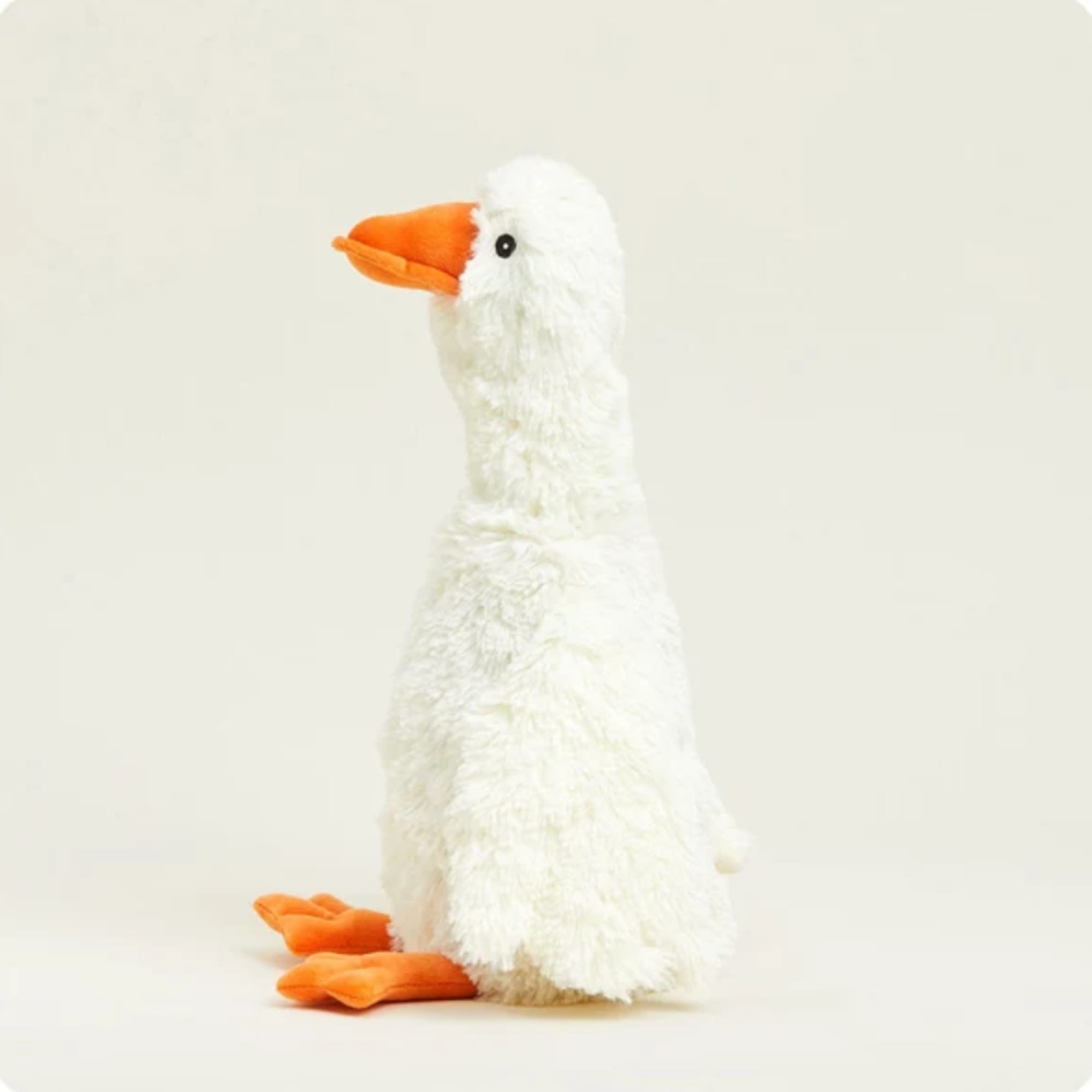 White plush goose with an orange beak and feet on a plain background