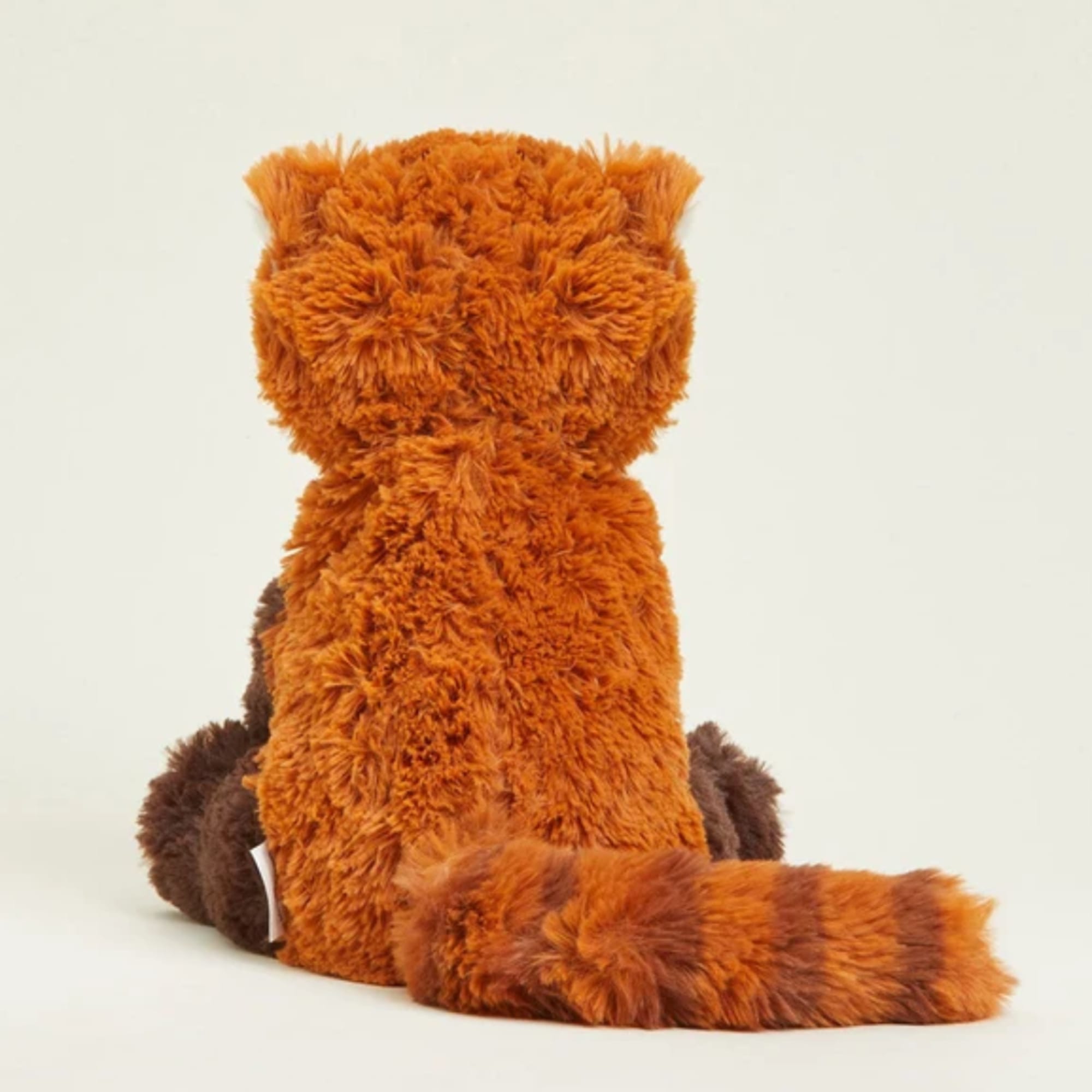 Orange and brown plush cat toy sitting upright on a plain background