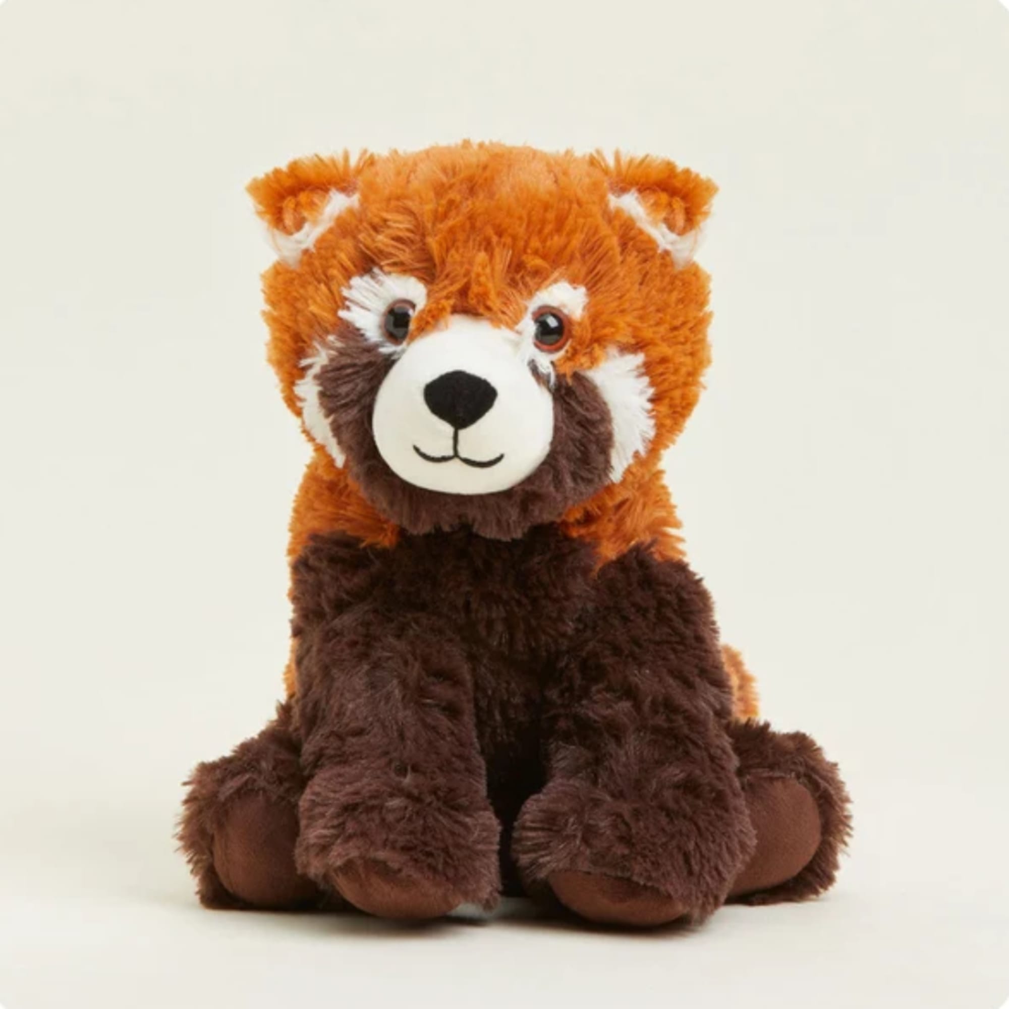 Plush red panda teddy bear sitting against a plain background